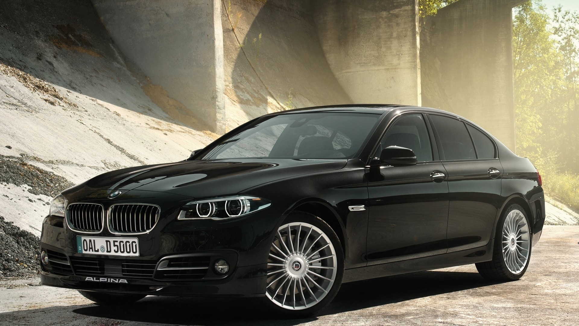 арафированный вид на черный седан bmw, припаркованный перед мостом