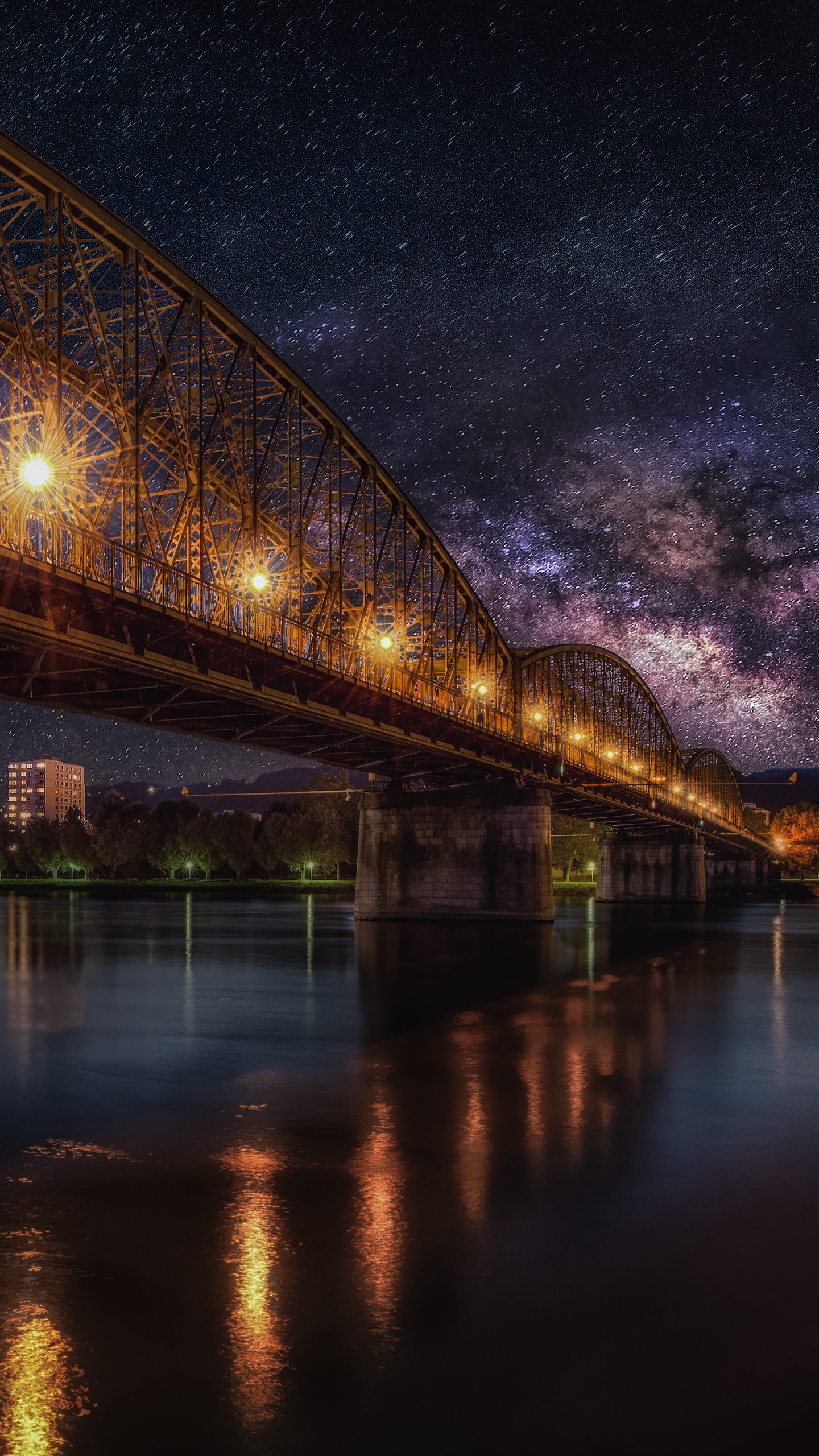 звездное ночное небо над мостом и городом