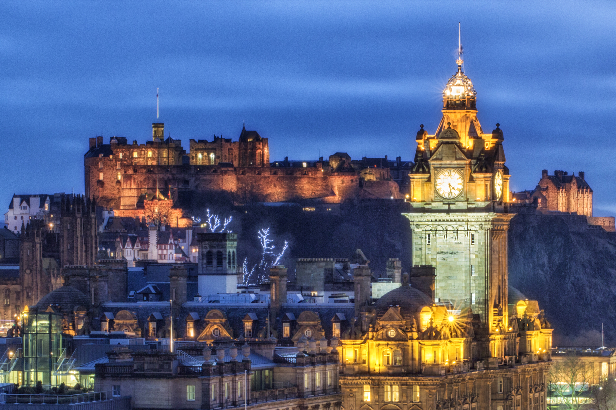 вид на город с башней с часами и замком на заднем плане