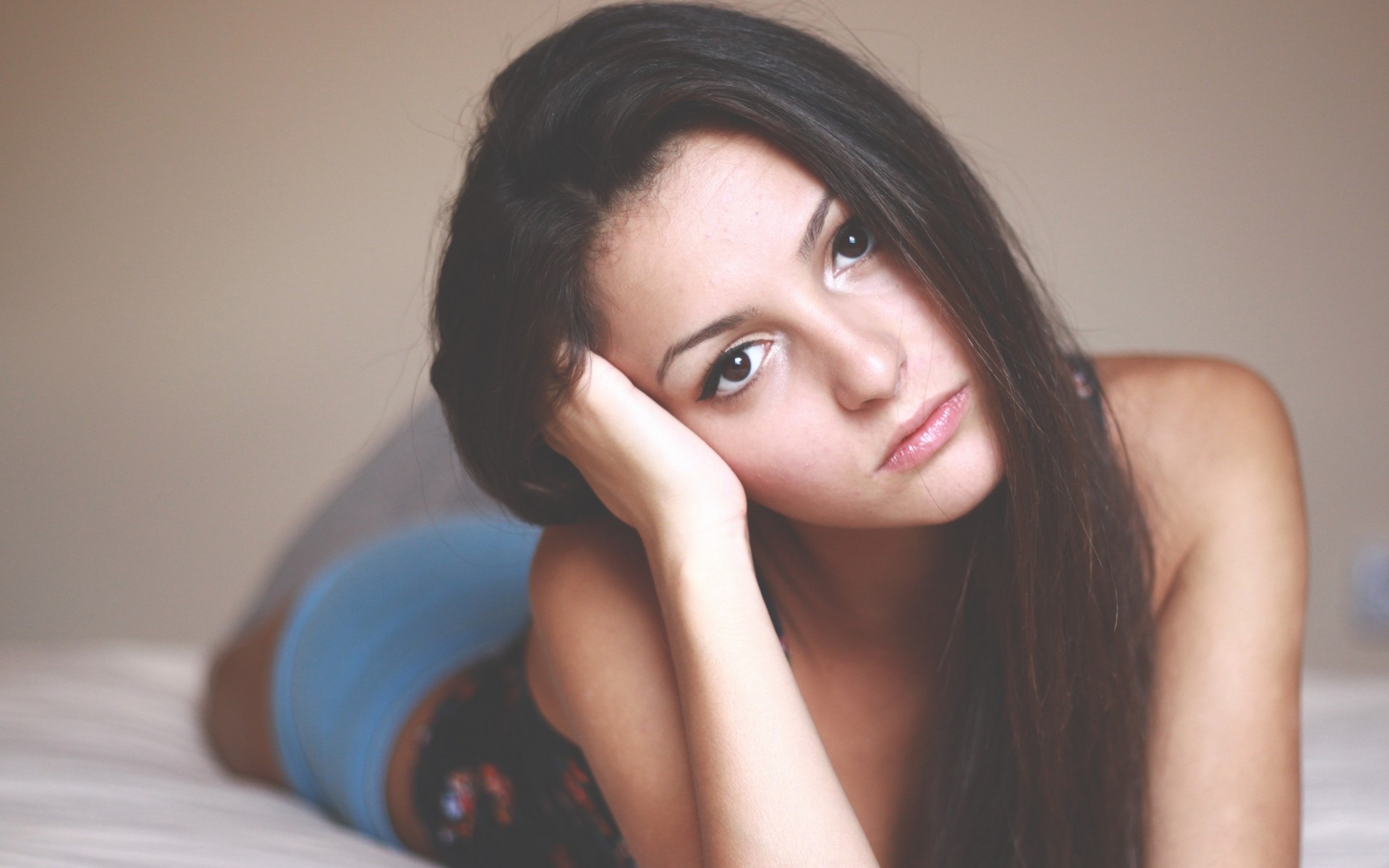 женщина лежит на кровати с головой на руках