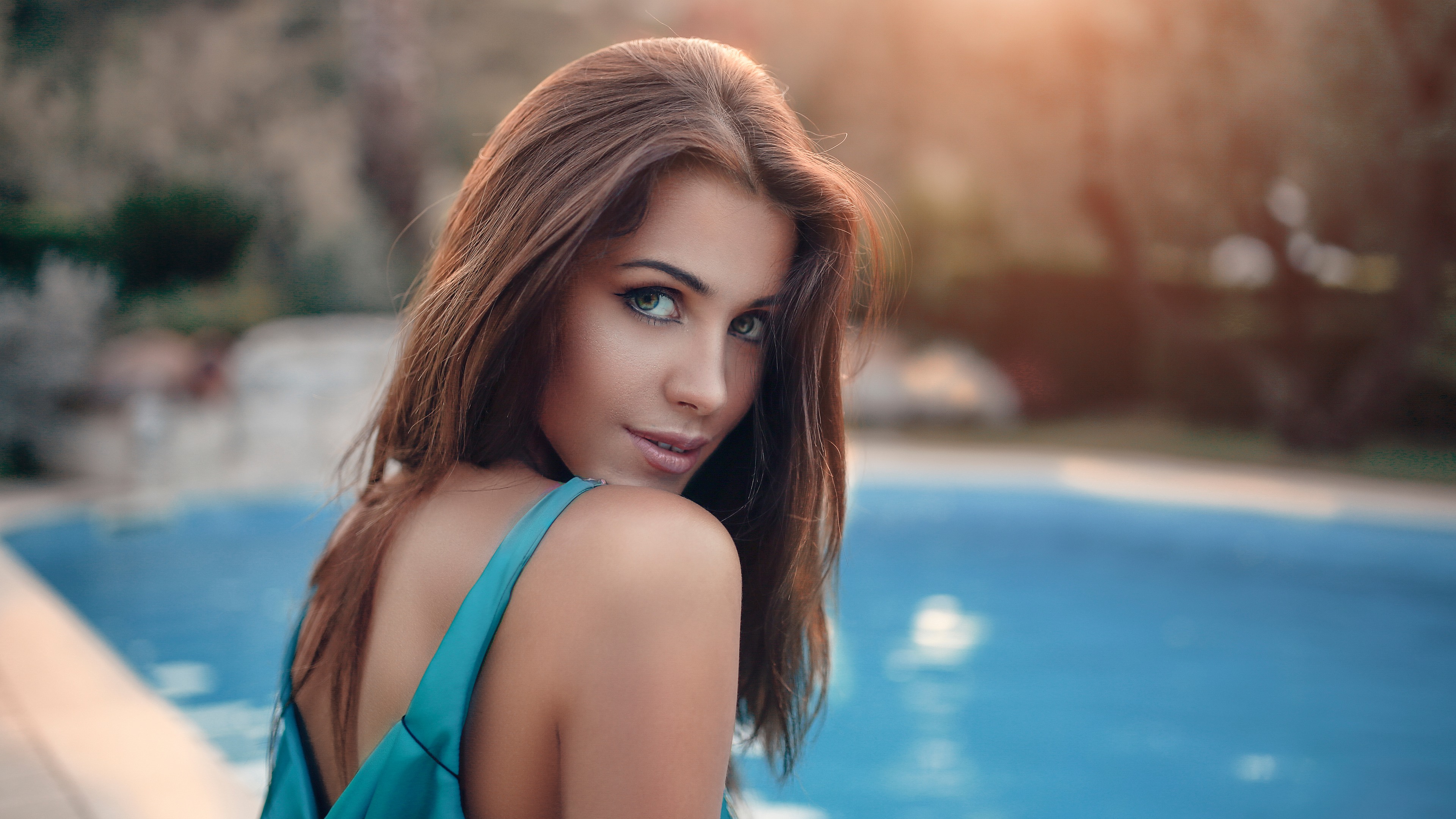 женщина в синем платье рядом с бассейном