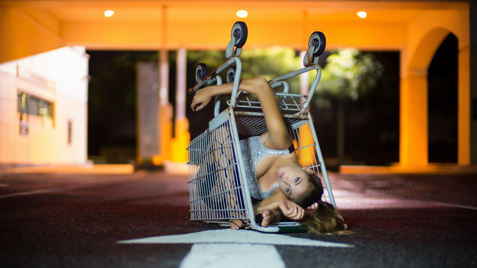 на земле лежит женщина с тележкой для покупок