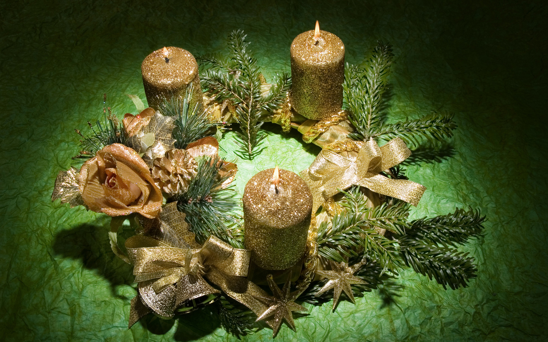 есть три свечи, которые сидят на зеленой ткани