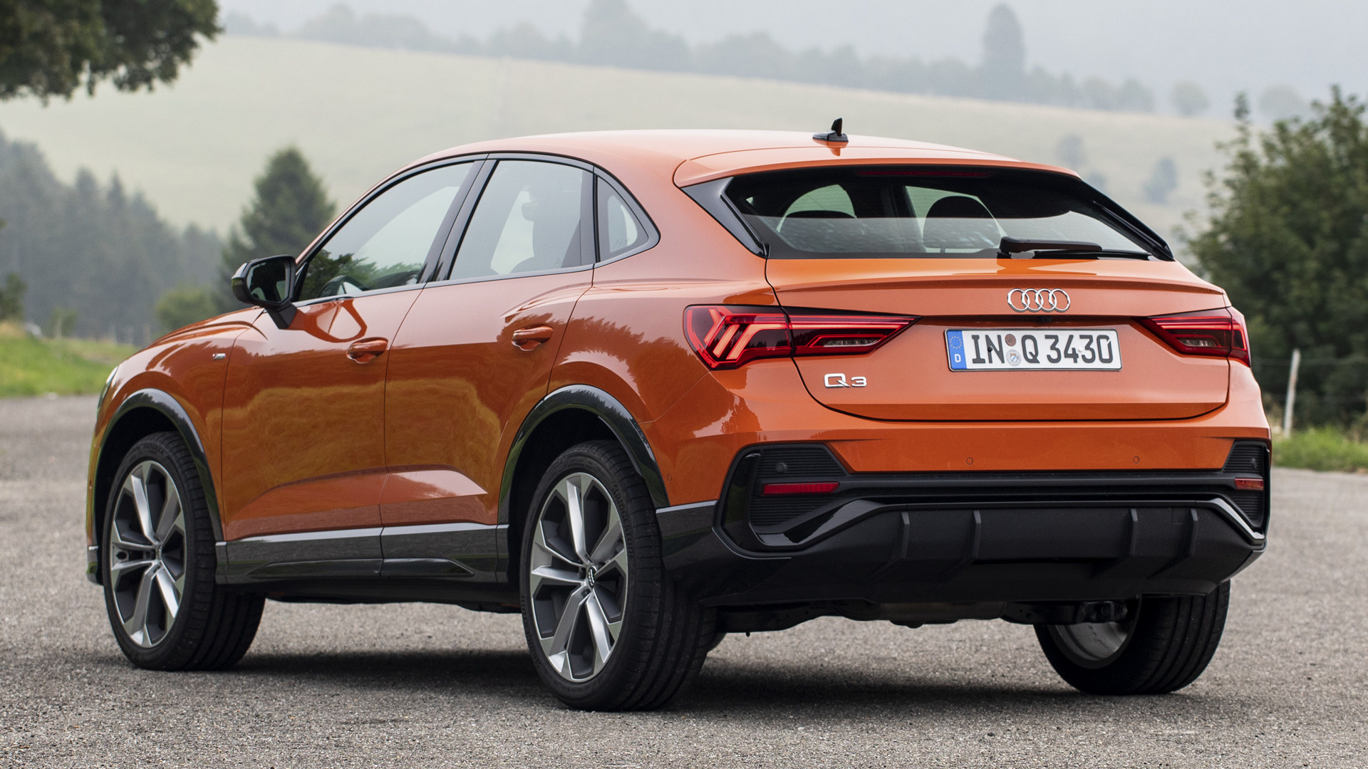 оранжевый audi suv припаркован на дороге