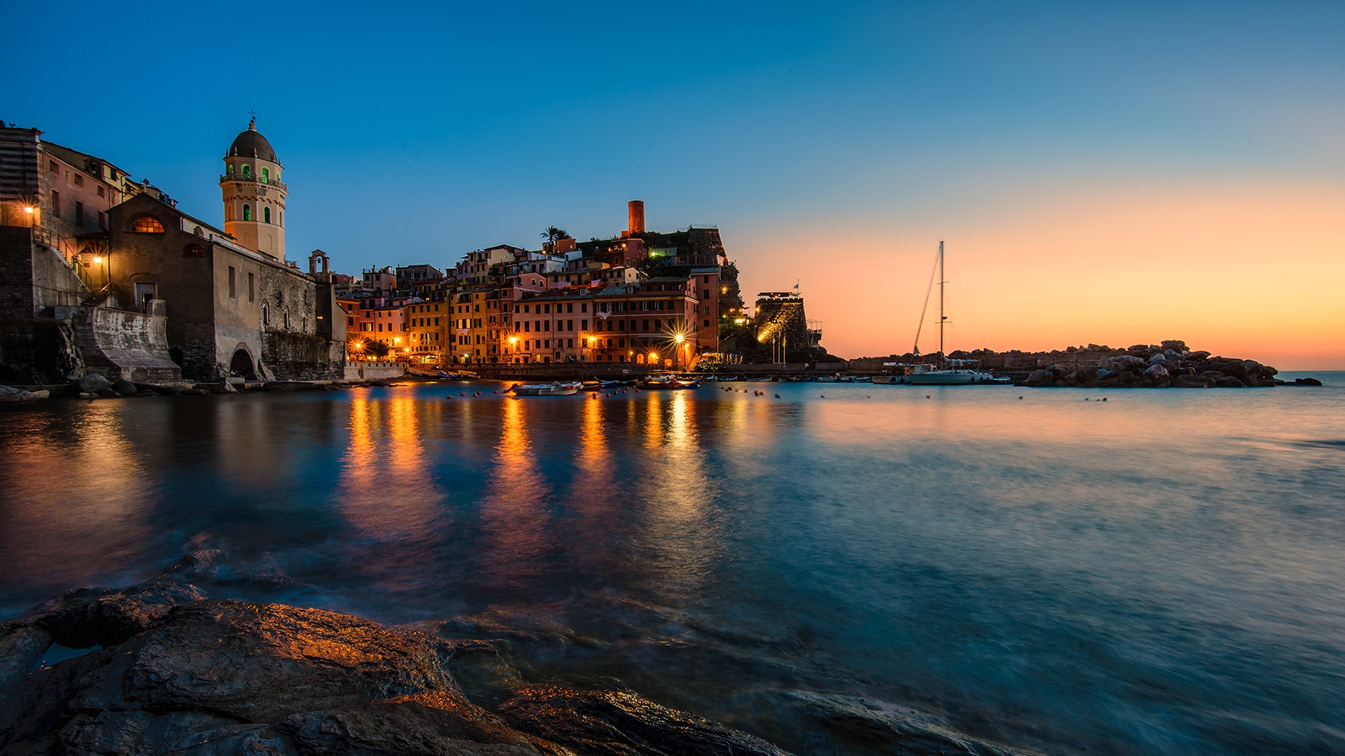 вид на город с башней с часами и водоемом