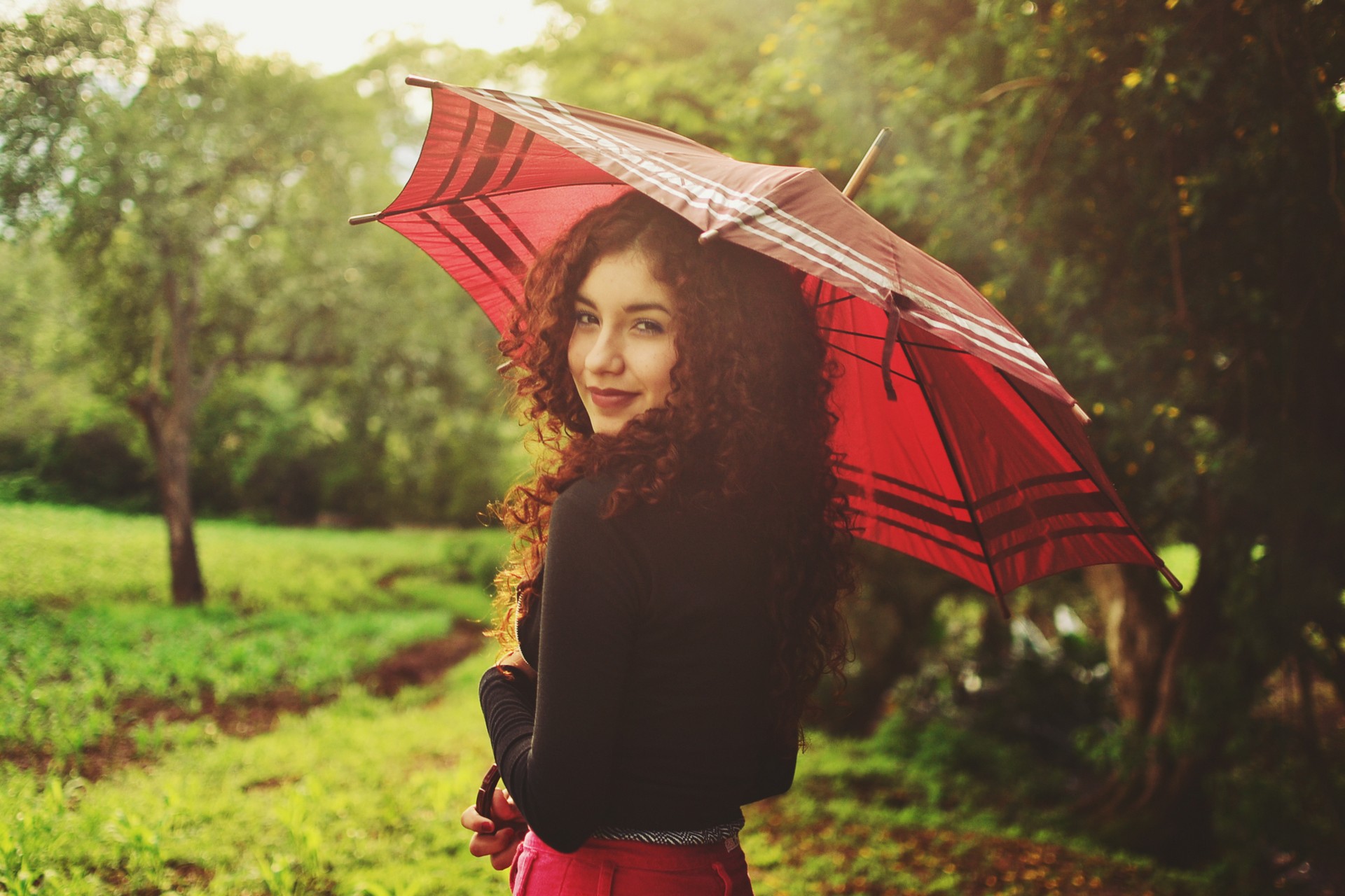 женщина держит в парке зонтик