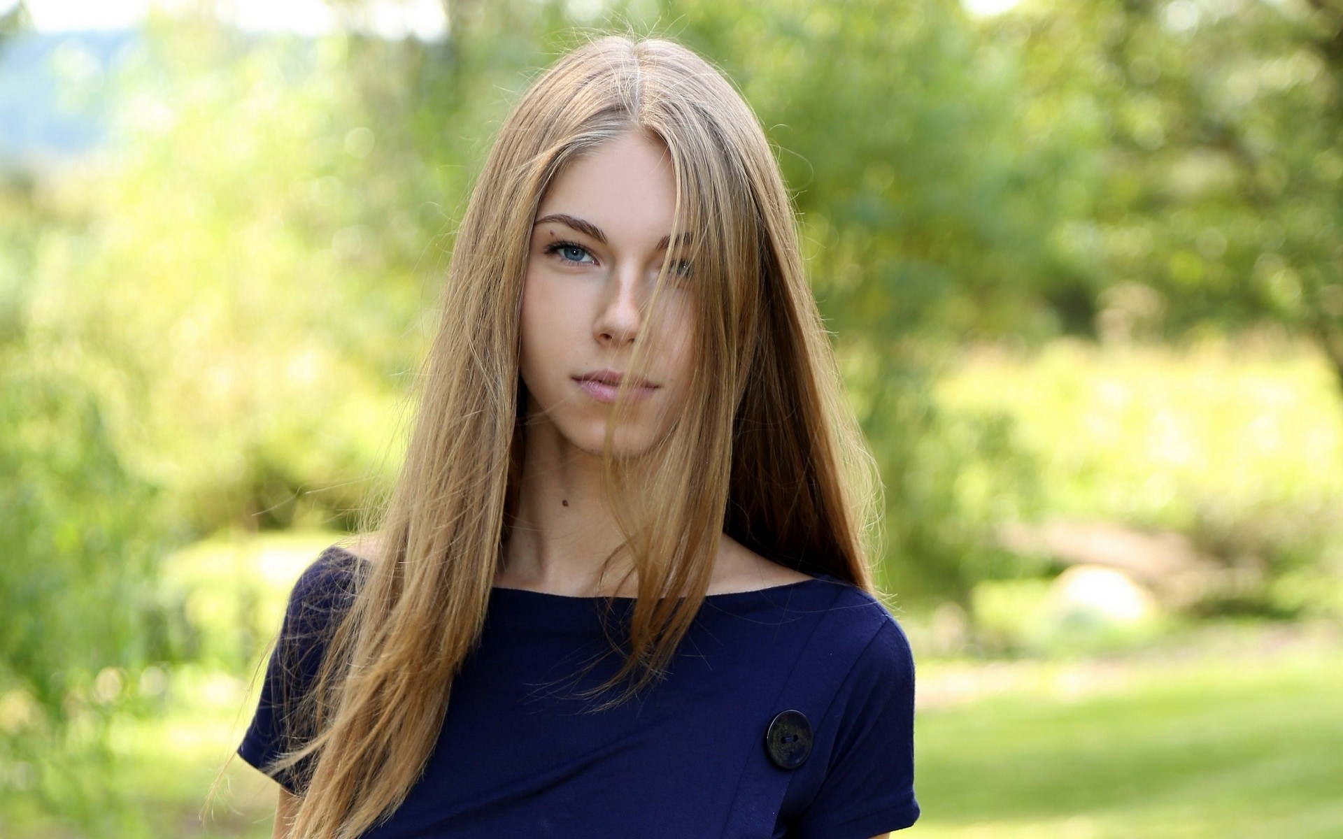 женщина с длинными волосами и синим платьем, стоящая в поле