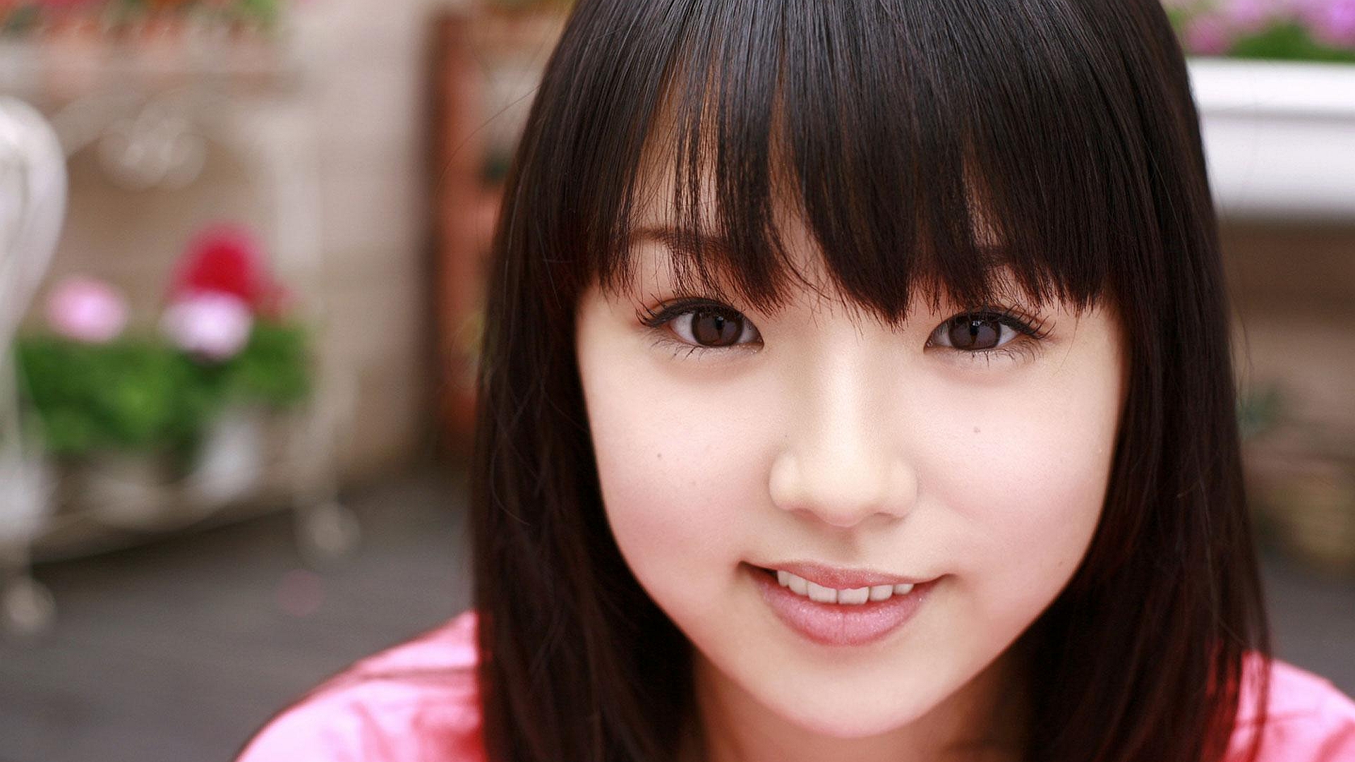 молодая женщина в розовой рубашке улыбается на камеру