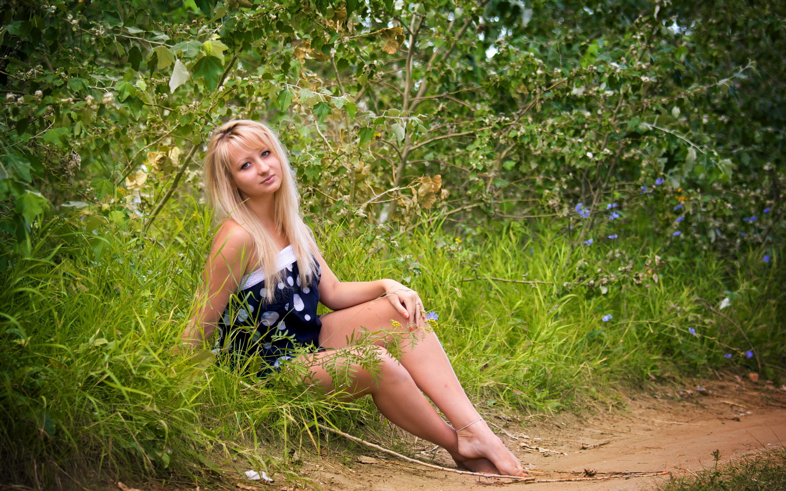 Молодая позирует на камеру. Блондинка в лесу. Молодая блондинка на природе. Девушка в платье.