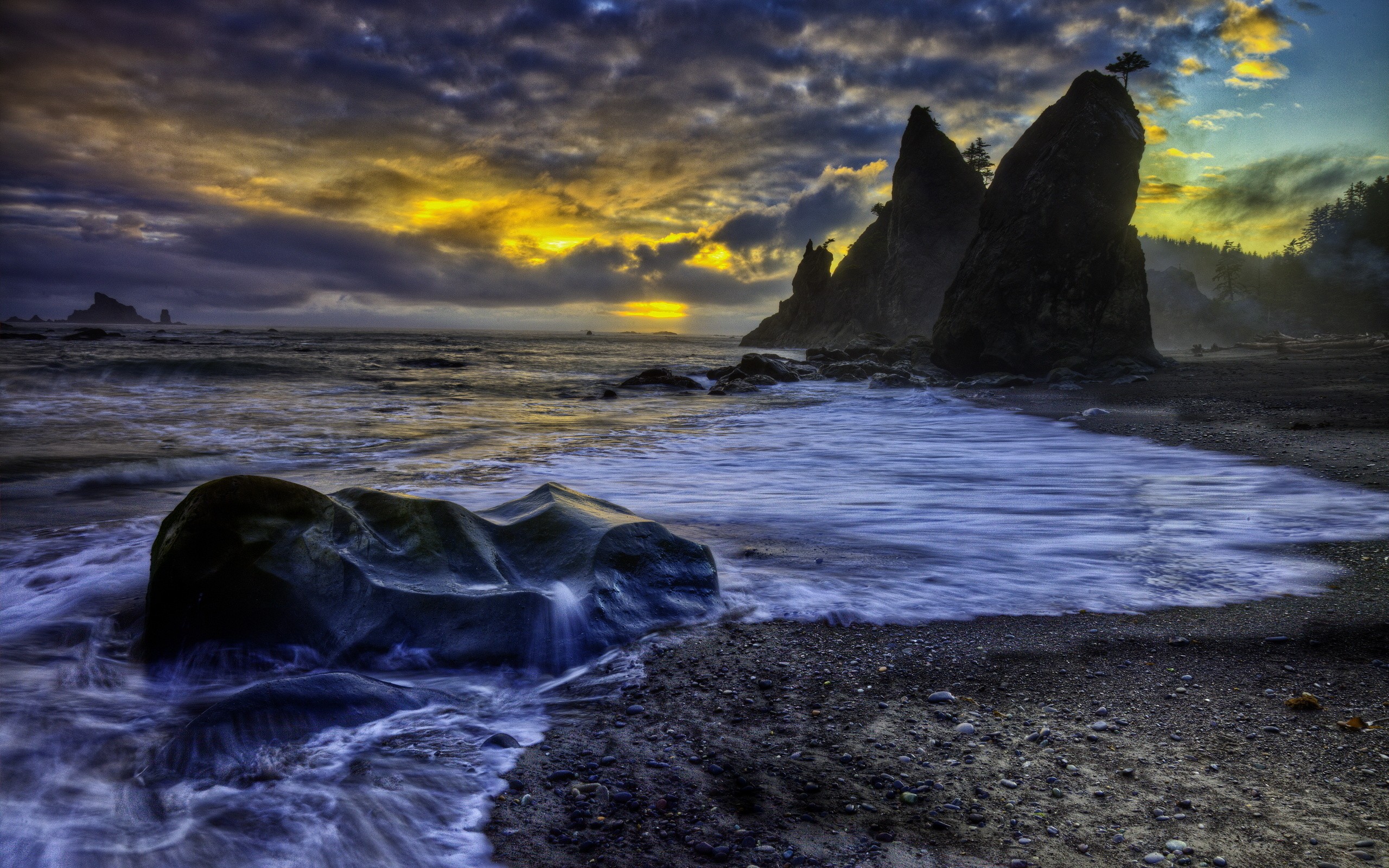 вид на пляж с камнями и волнами на закате