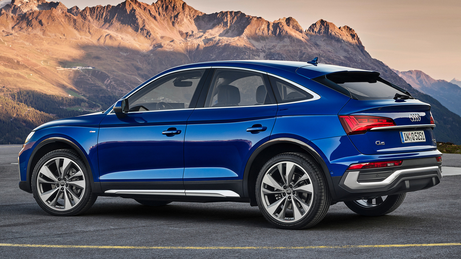 синий аудио-сув, припаркованный перед горой