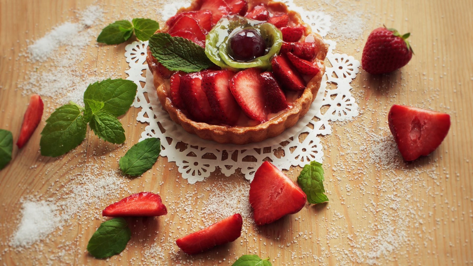 есть выпечка с клубникой и листья мяты на куколке