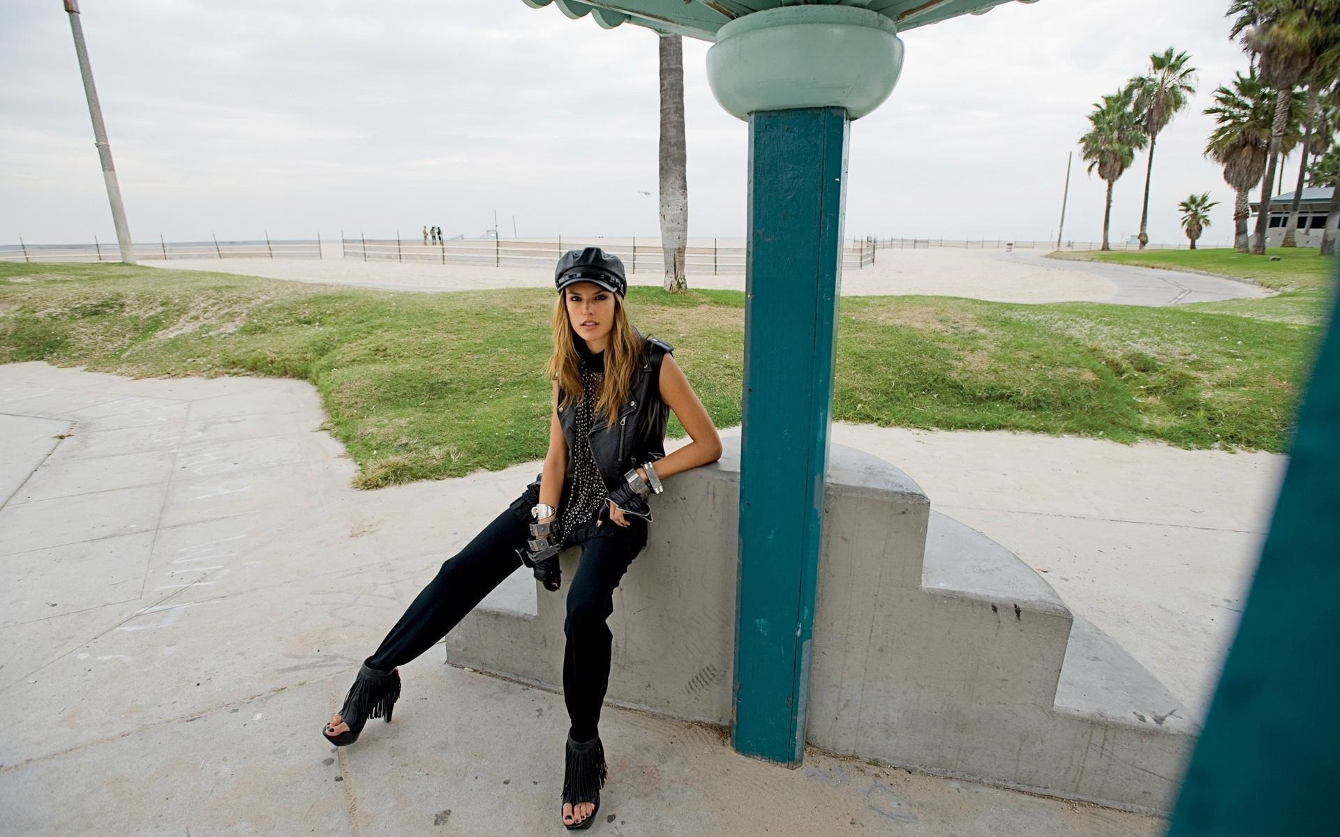 женщина сидит на цементной стене с фотоаппаратом