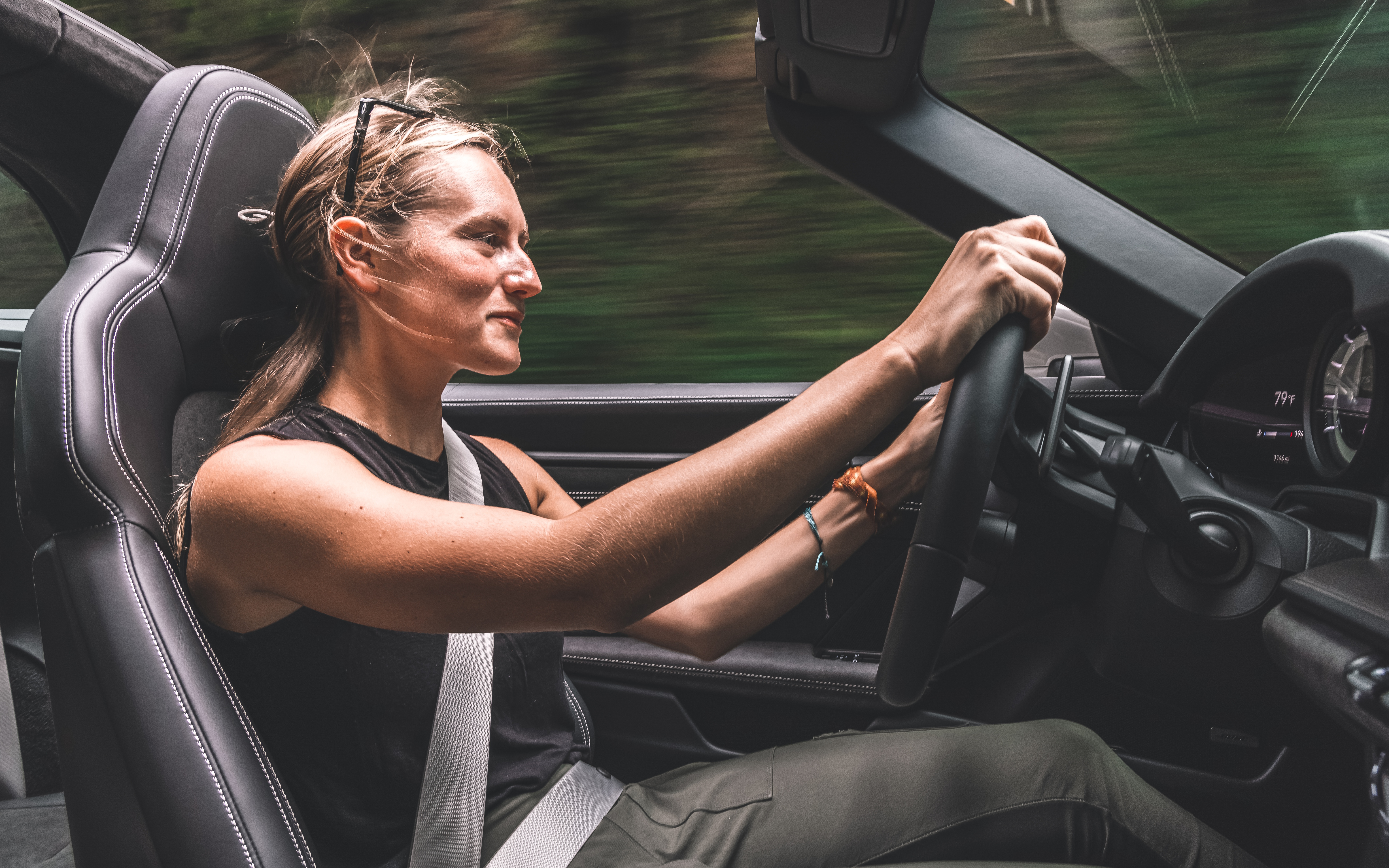 женщина за рулем автомобиля с рулем и черным сиденьем