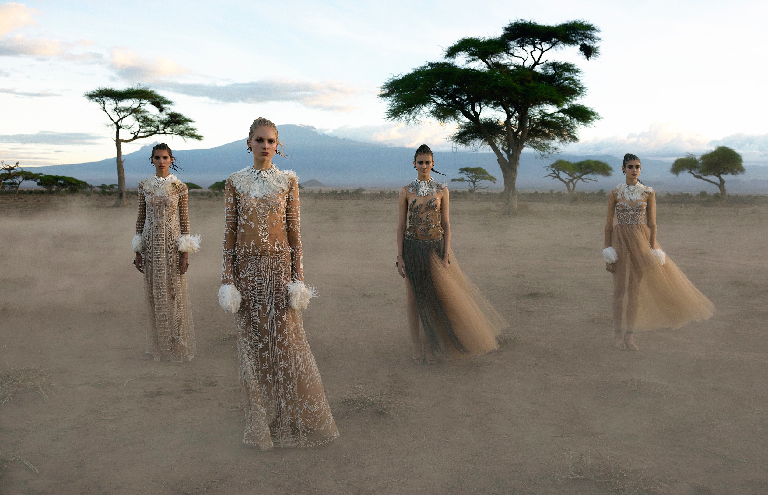 несколько женщин в длинных платьях гуляют по песку