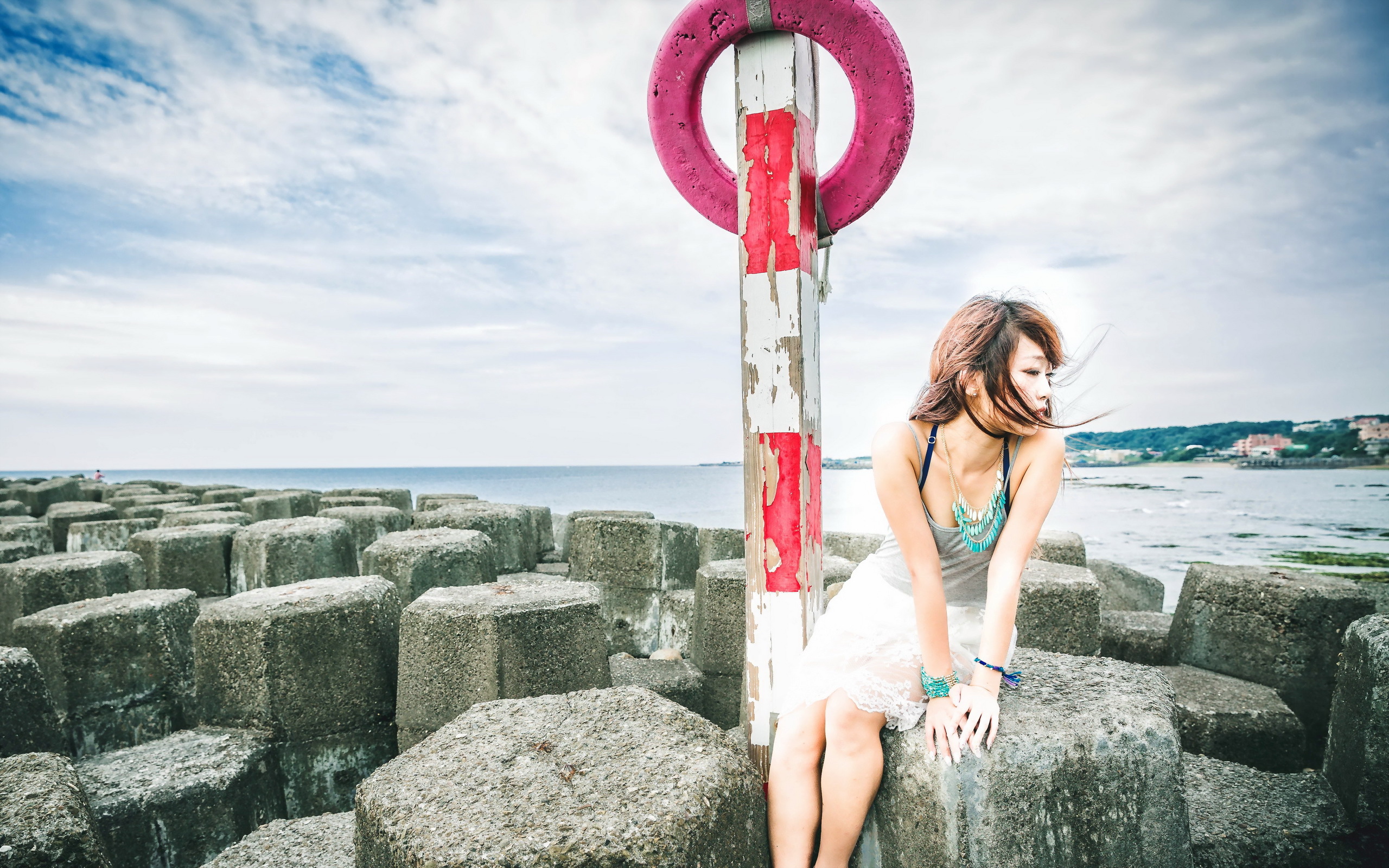 есть женщина, сидящая на скале с спасательным кругом