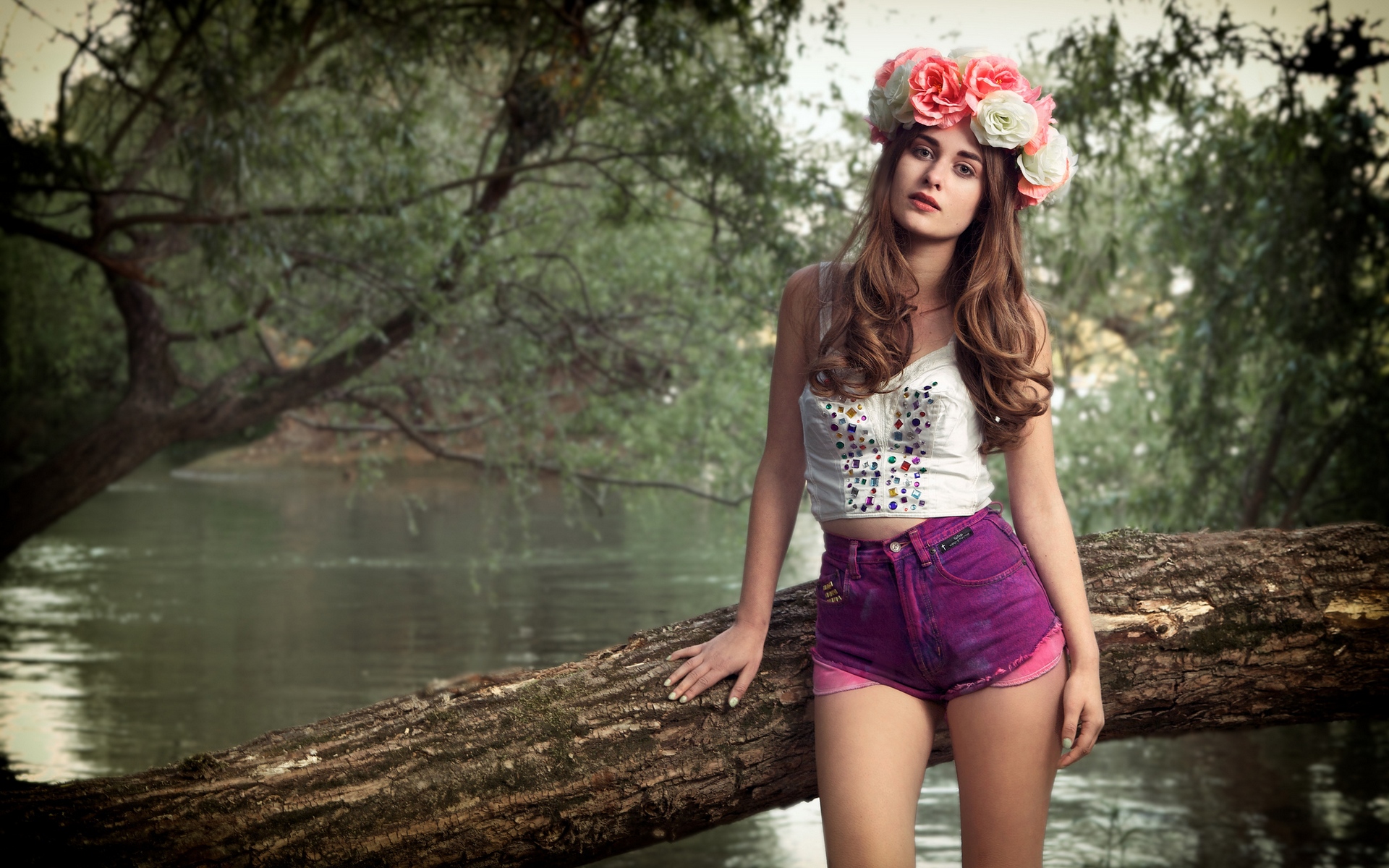 женщина, стоящая на бревне в реке с цветочной короной