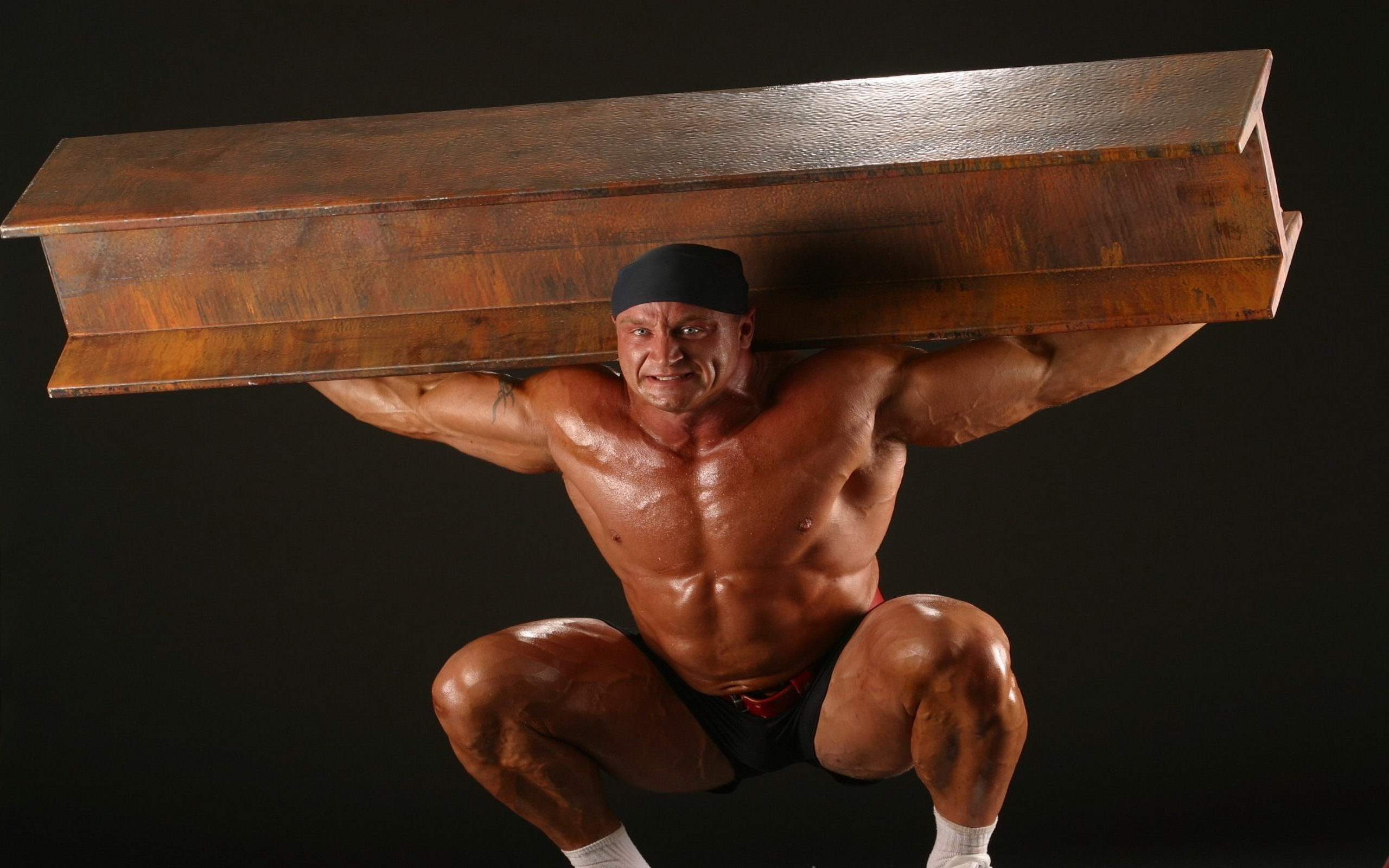 мужчина держит на голове большой деревянный предмет