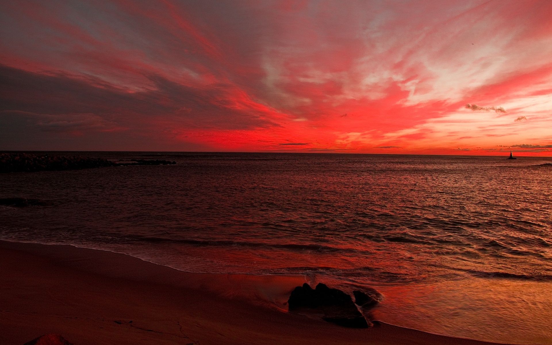 закат на пляже с парой сидящих на песке