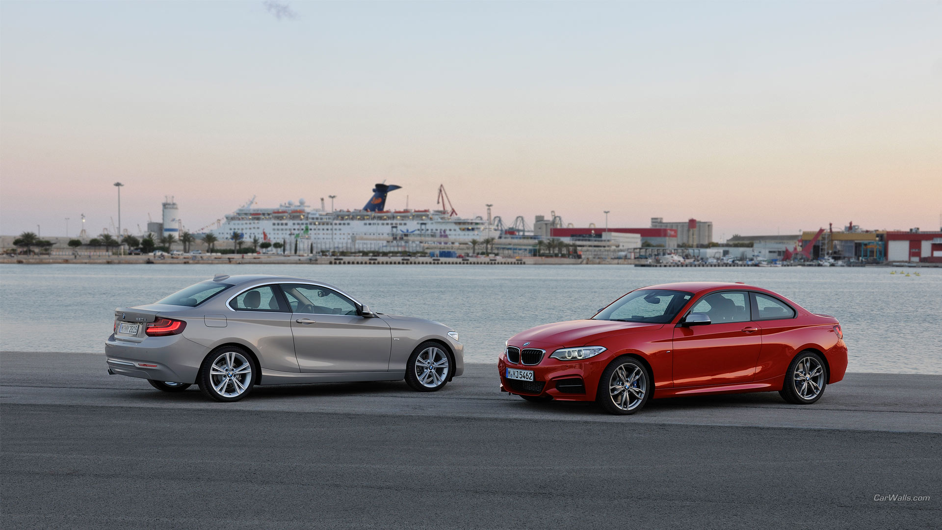 две машины припаркованы рядом друг с другом возле водоема