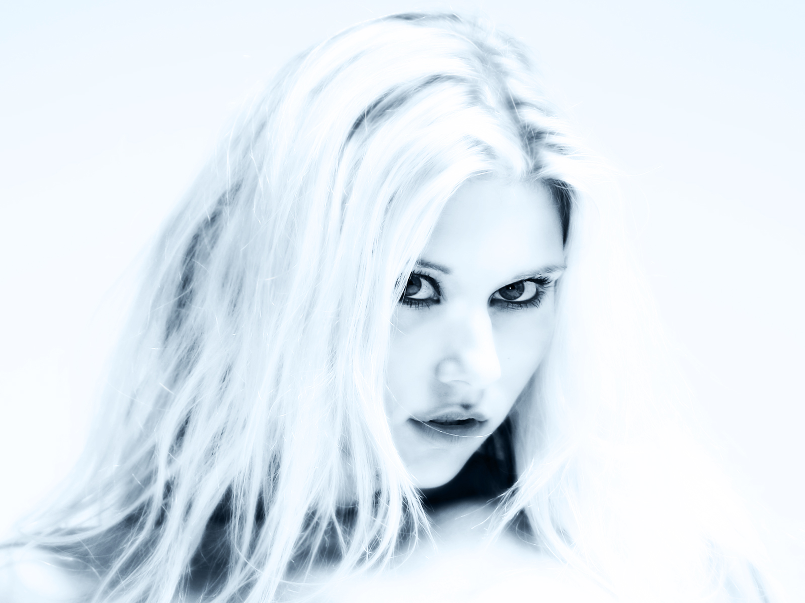 блондинка с длинными белыми волосами и черными глазами позирует для фото