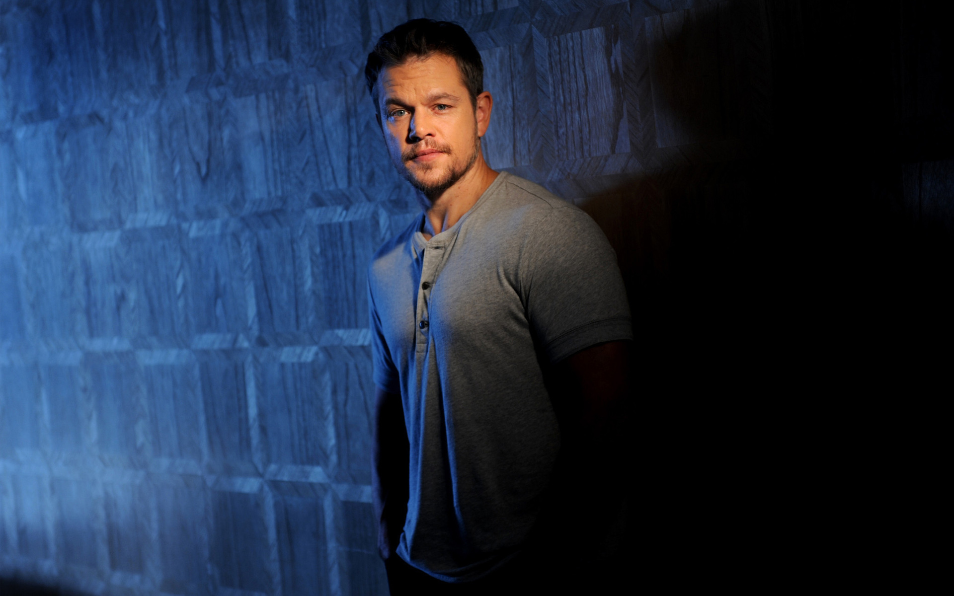 человек стоит перед стеной с синим светом