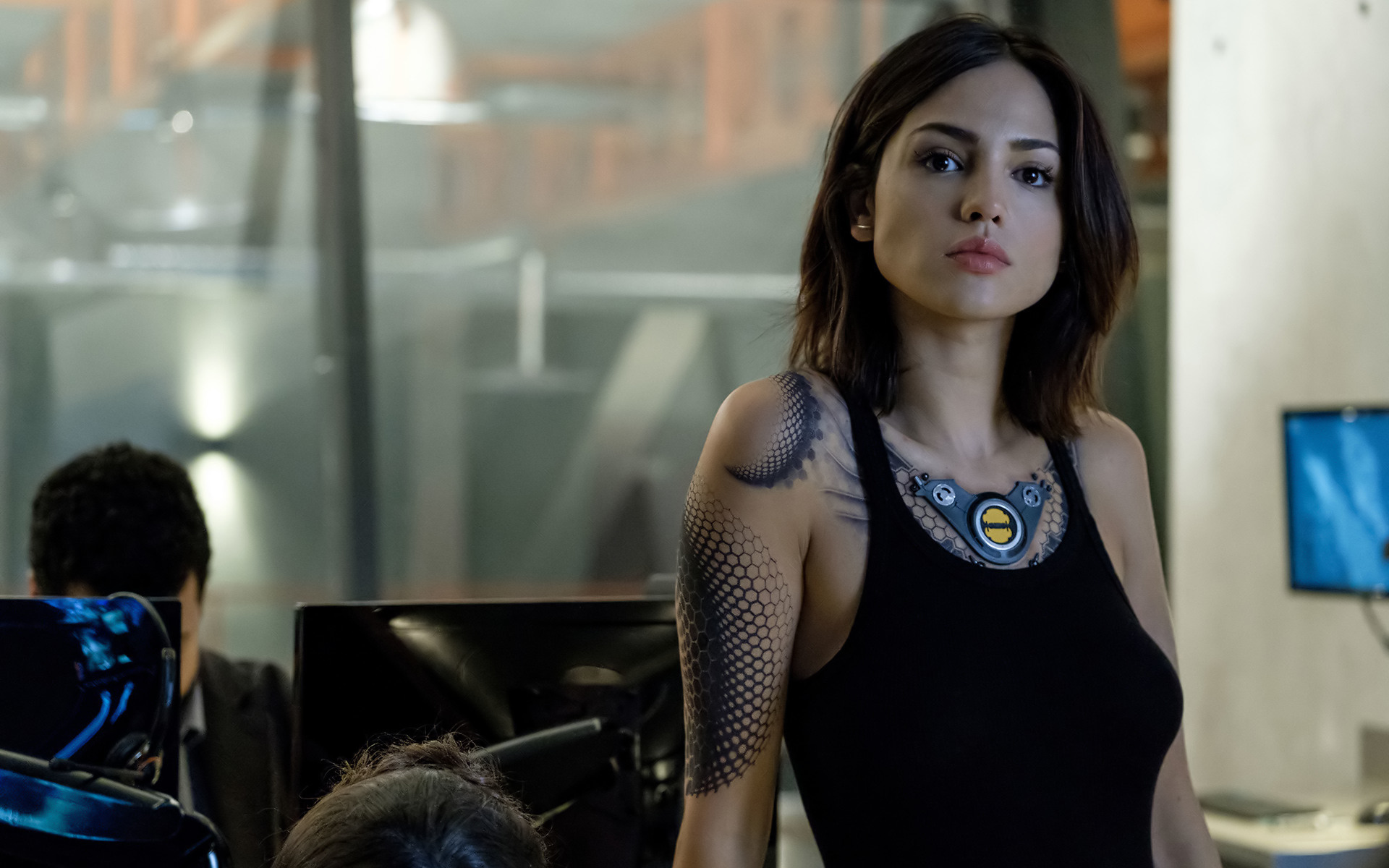 женщина с татуировкой на руке стоит перед компьютером