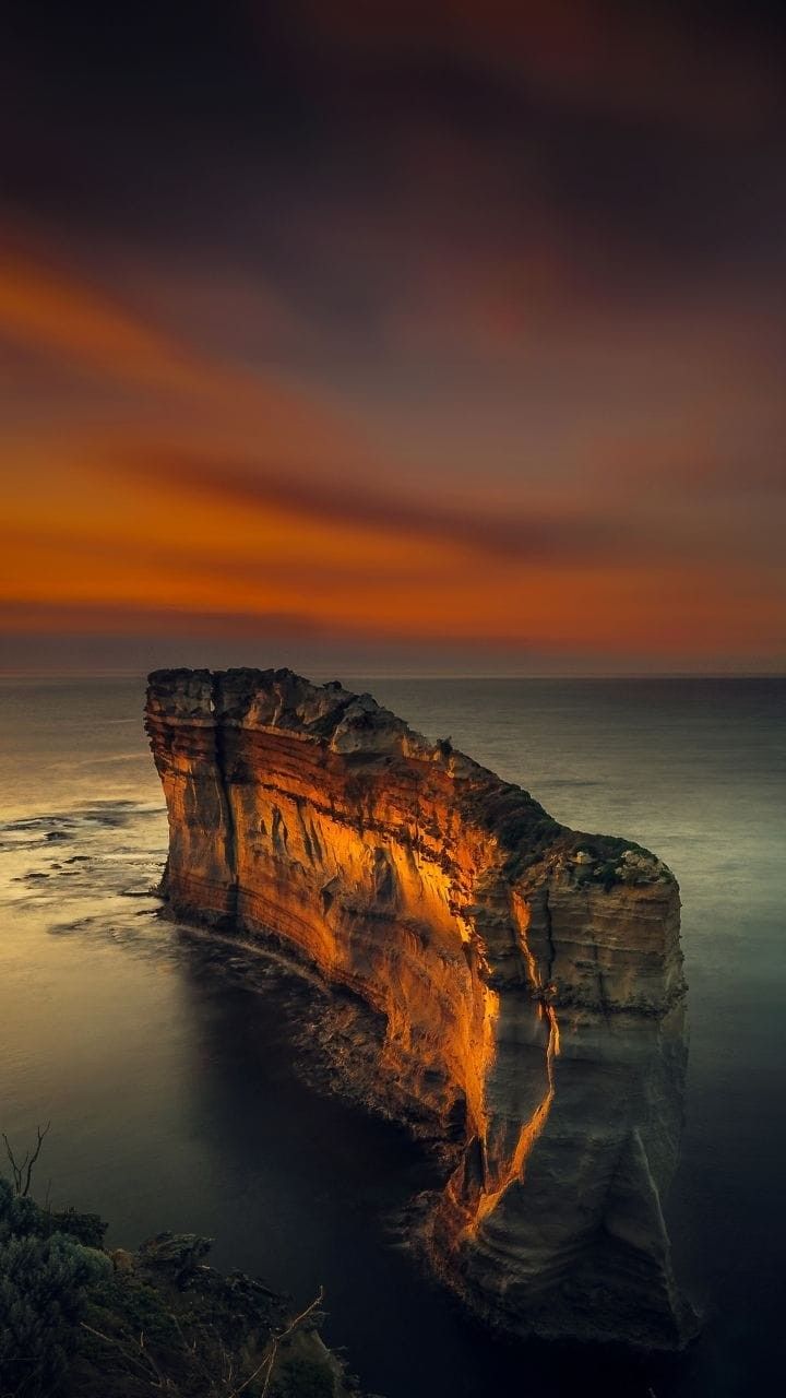 женщина скалообразование в океане на закате с небесным фоном