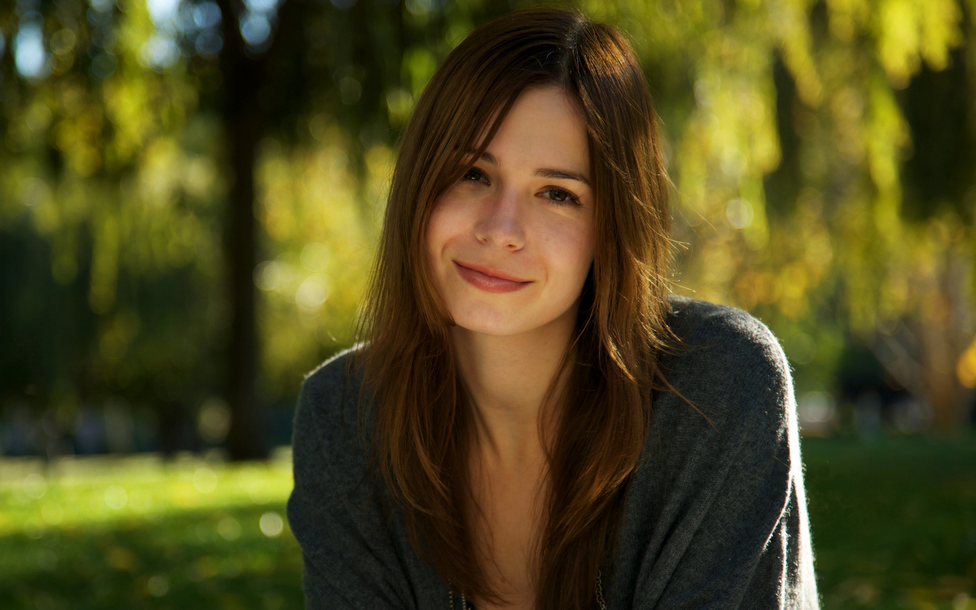 женщина, сидящая в парке на зеленом фоне