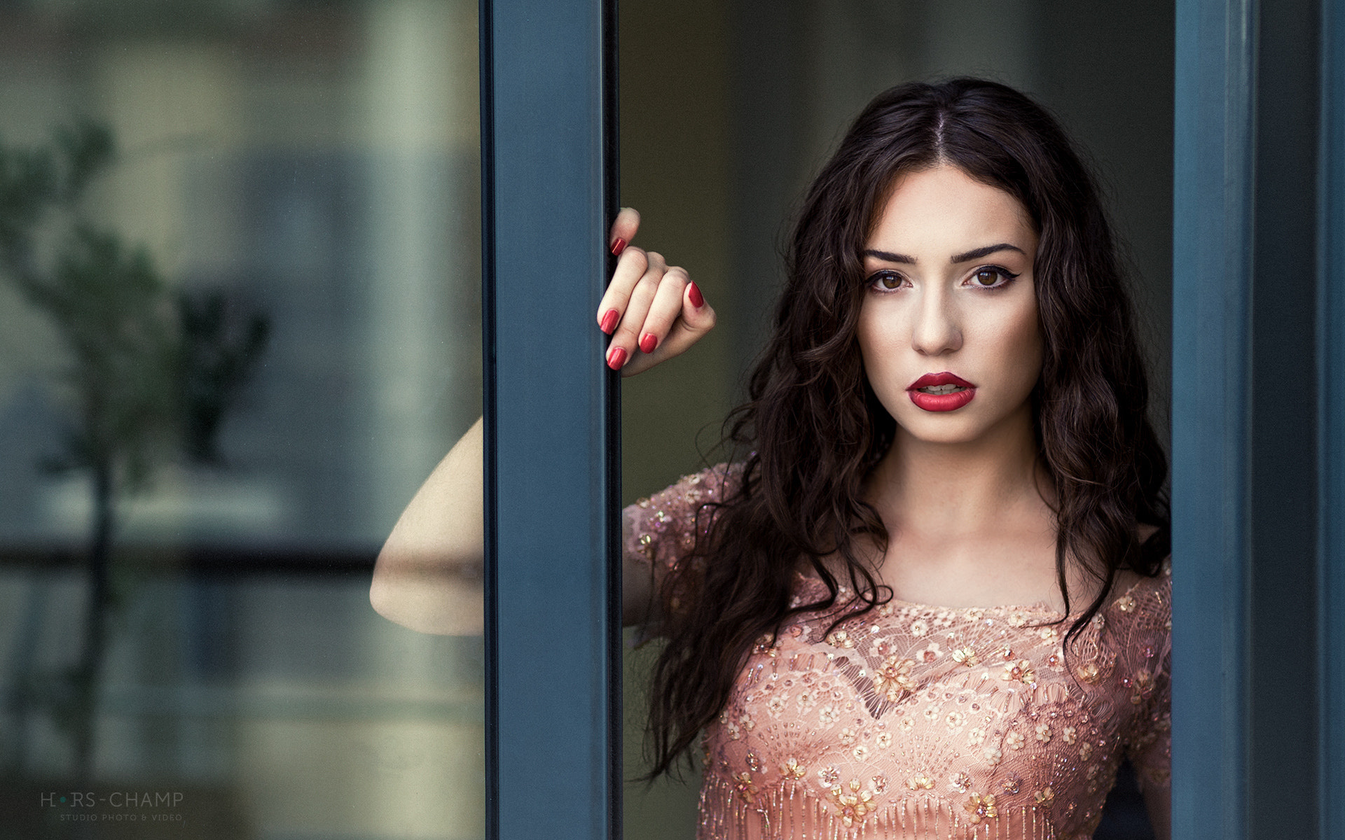 женщина в розовом платье смотрит в окно