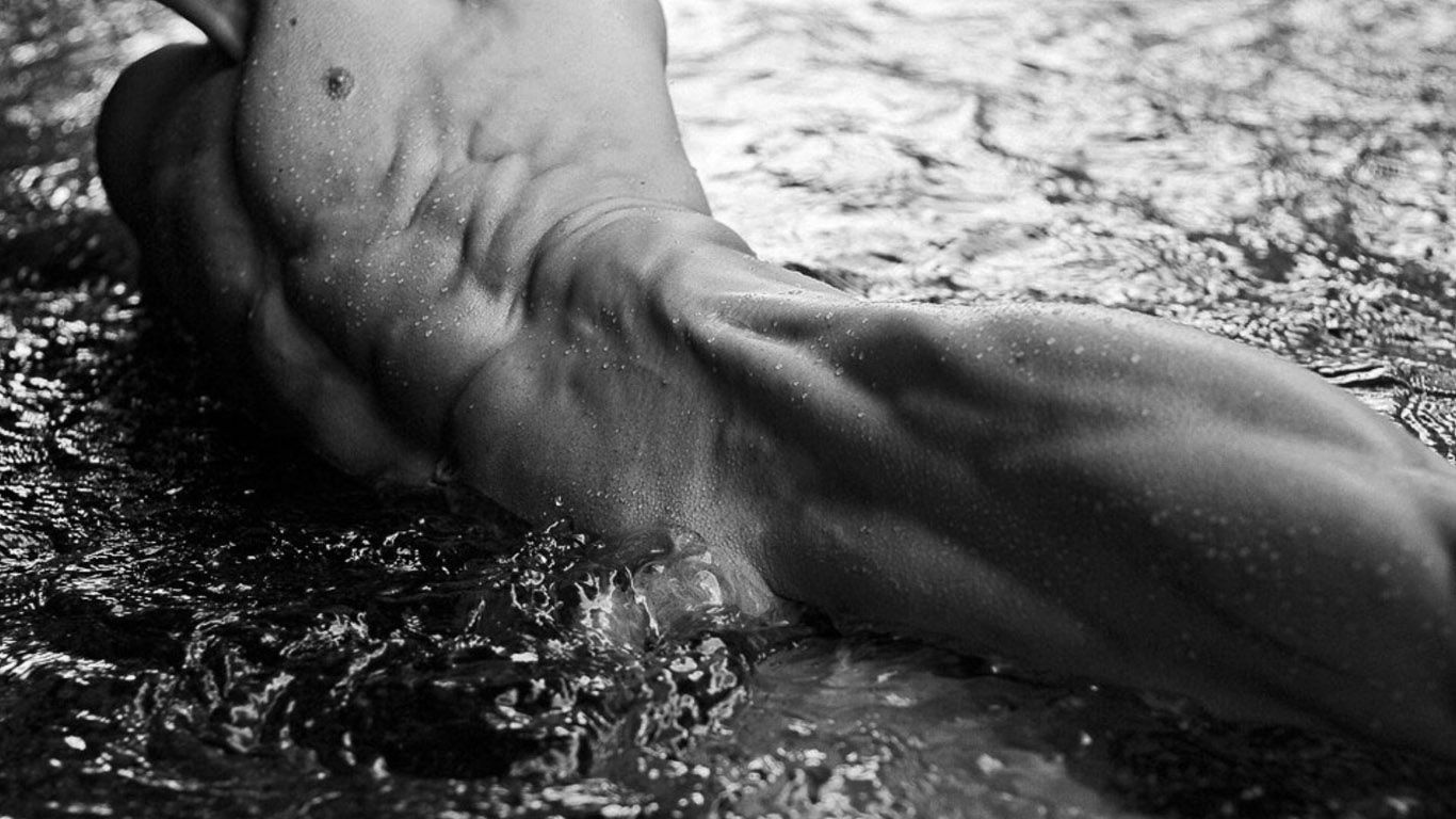 мужское тело в воде с босыми ногами и без рубашки