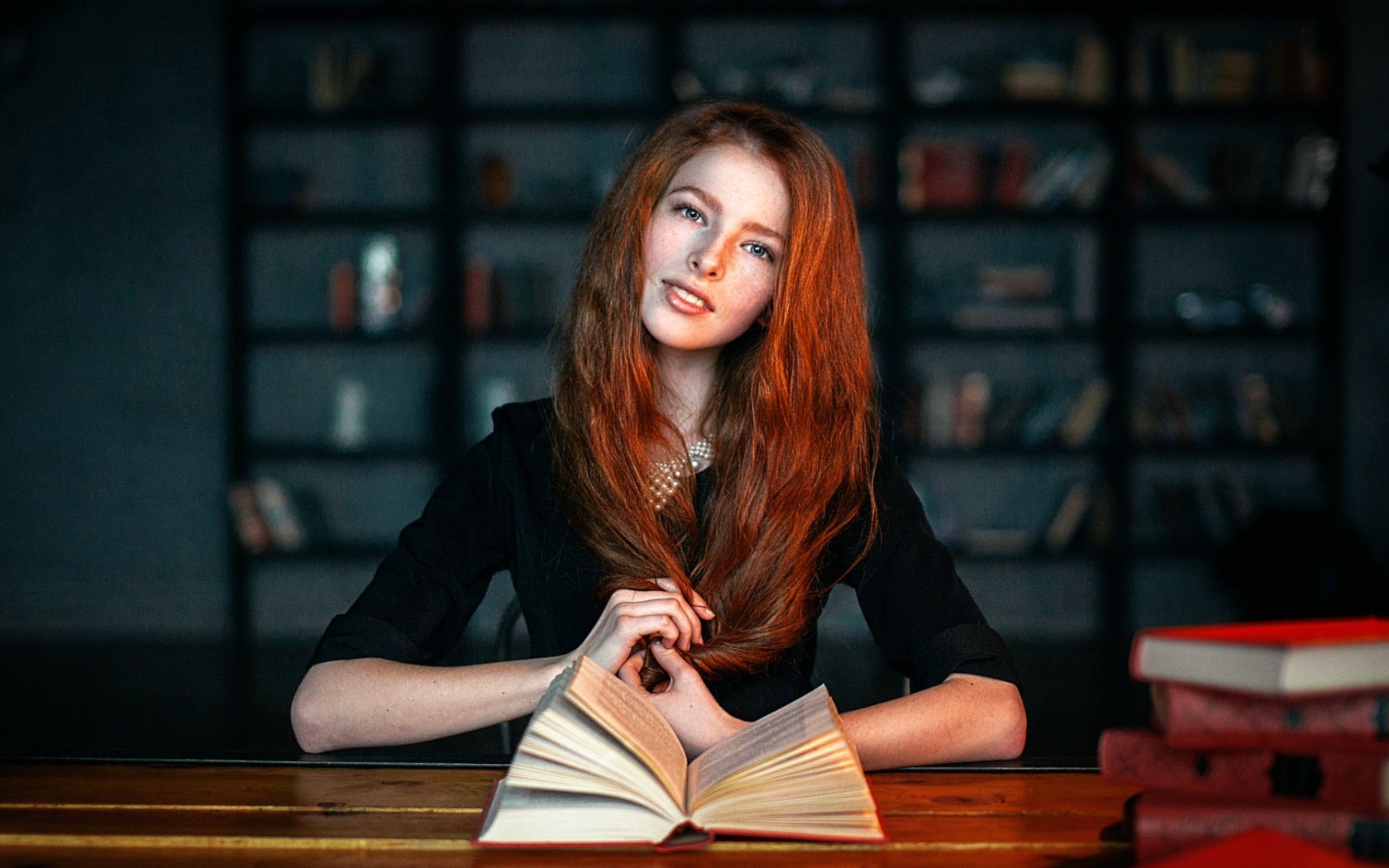 женщина сидит за столом с книгой