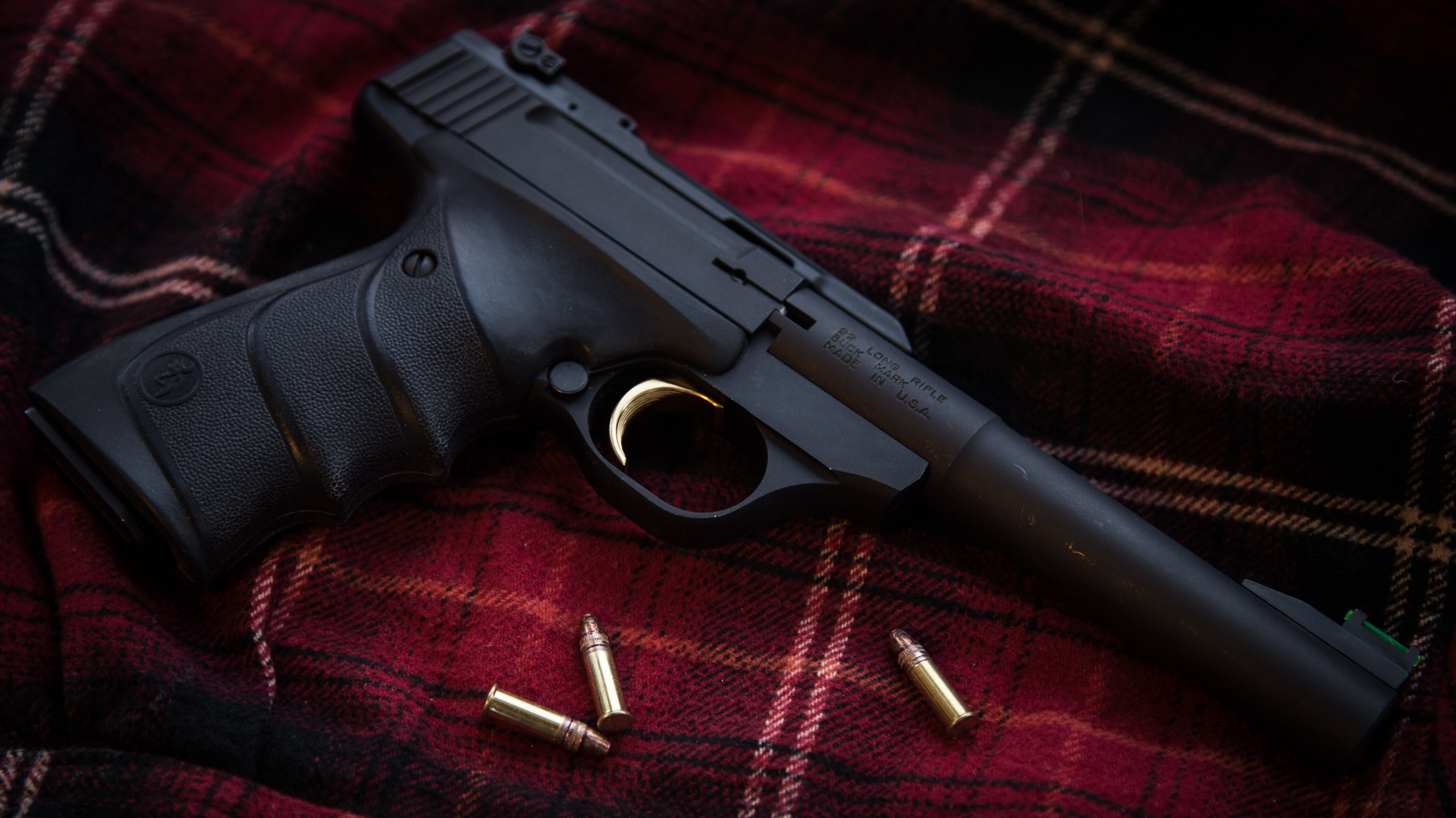 женский пистолет с пулей на клетчатом одеяле с пулей