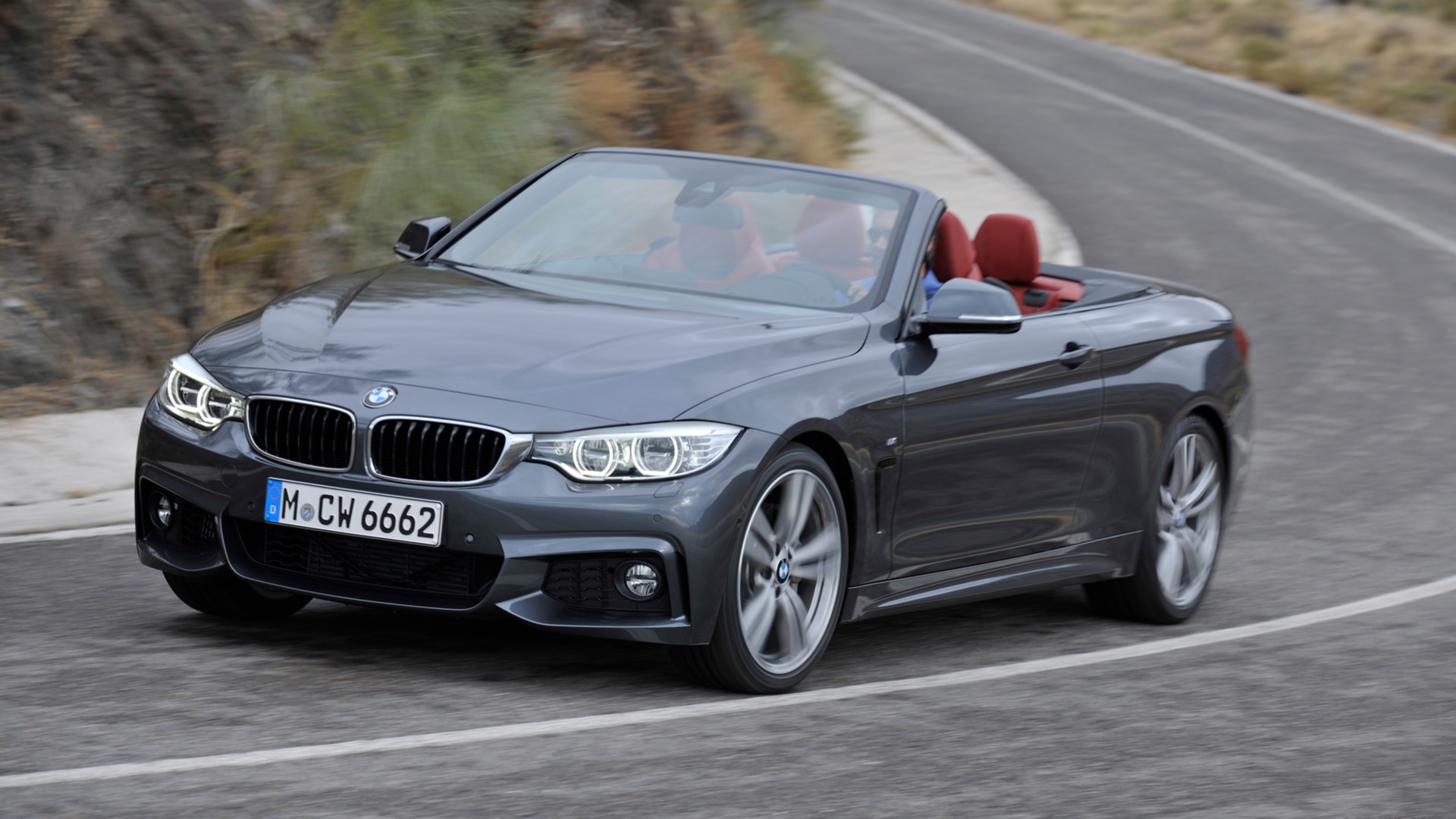 арафированный вид кабриолета bmw, едущего по извилистой дороге