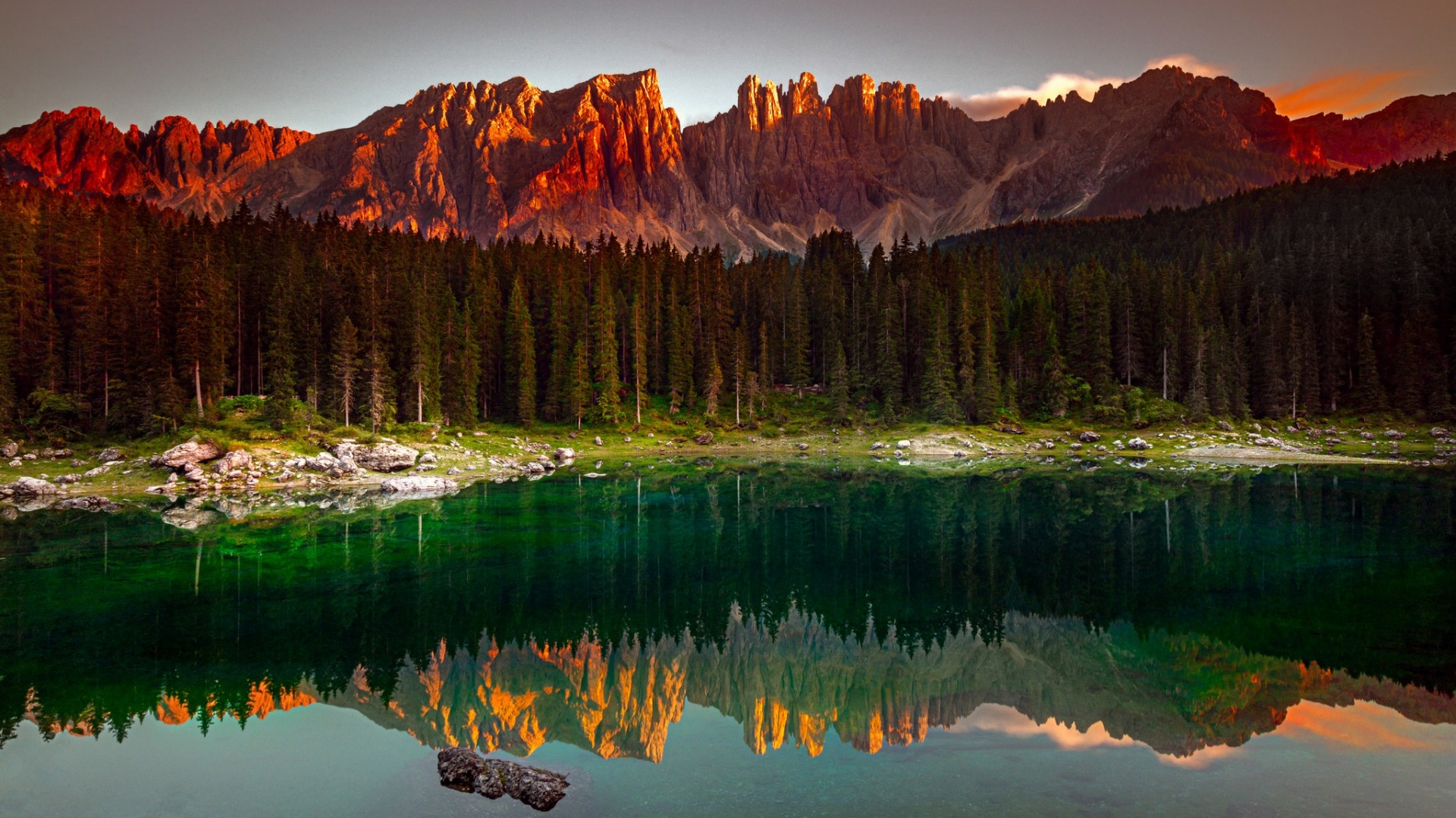 горы, отраженные в озере на закате с бревном на переднем плане
