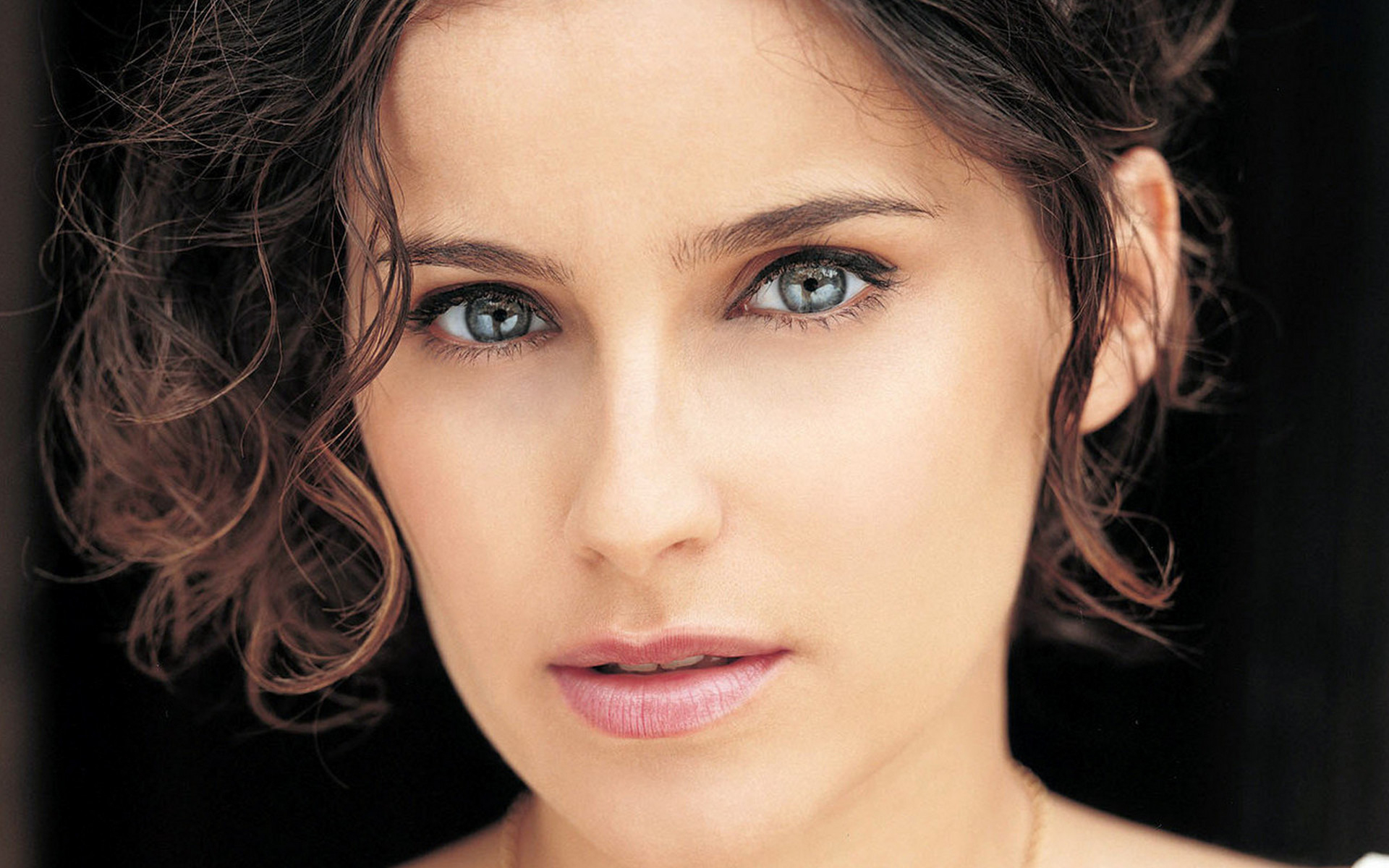 женщина с ожерельем на шее смотрит в камеру