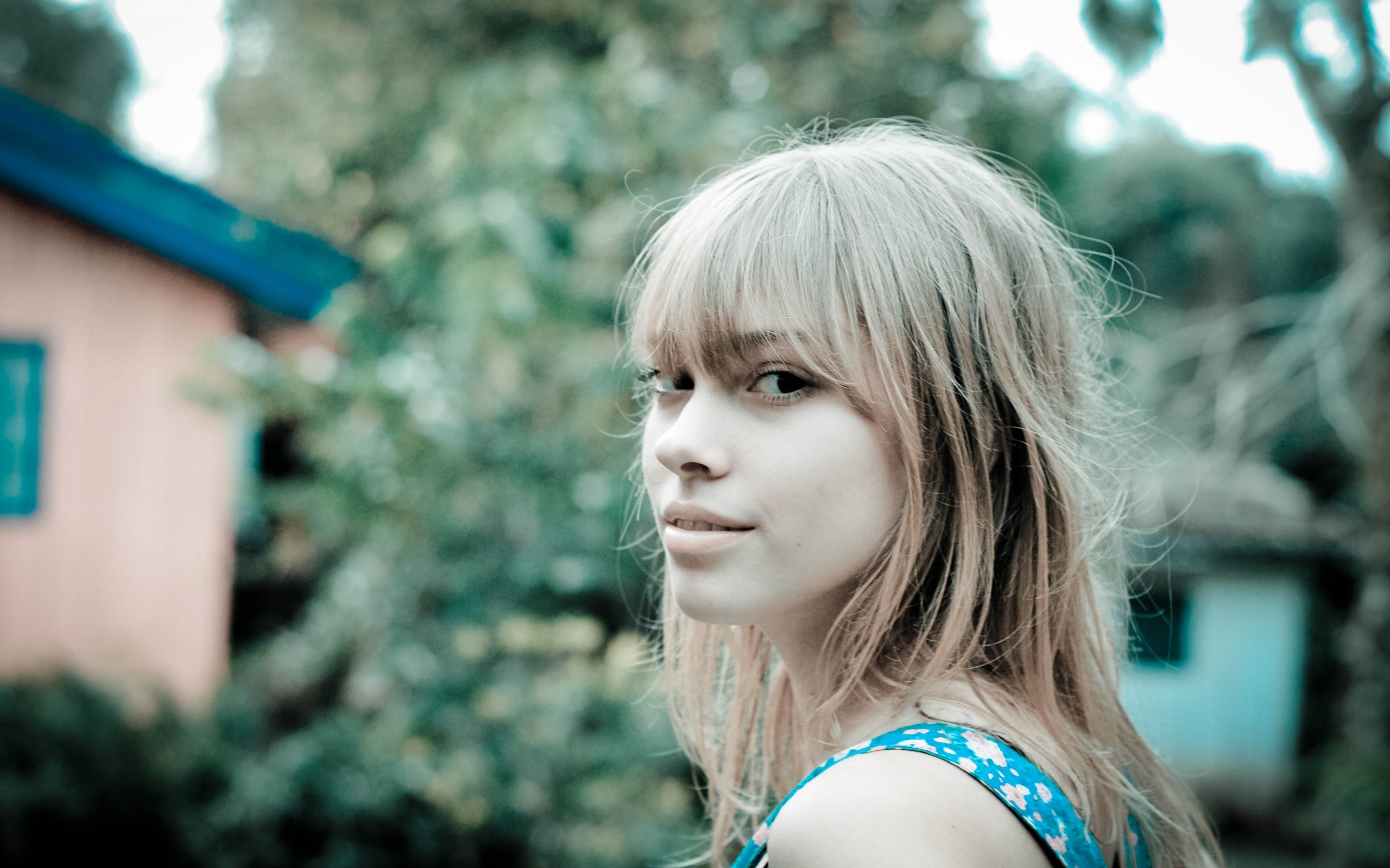 блондинка с синим платьем смотрит в сторону камеры