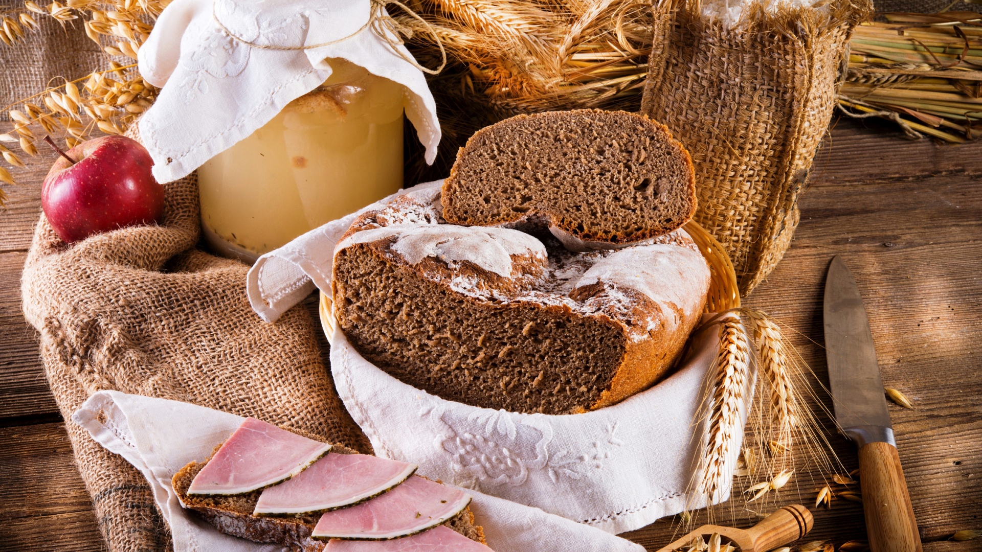 есть стол с хлебом, ветчиной и банкой варенья