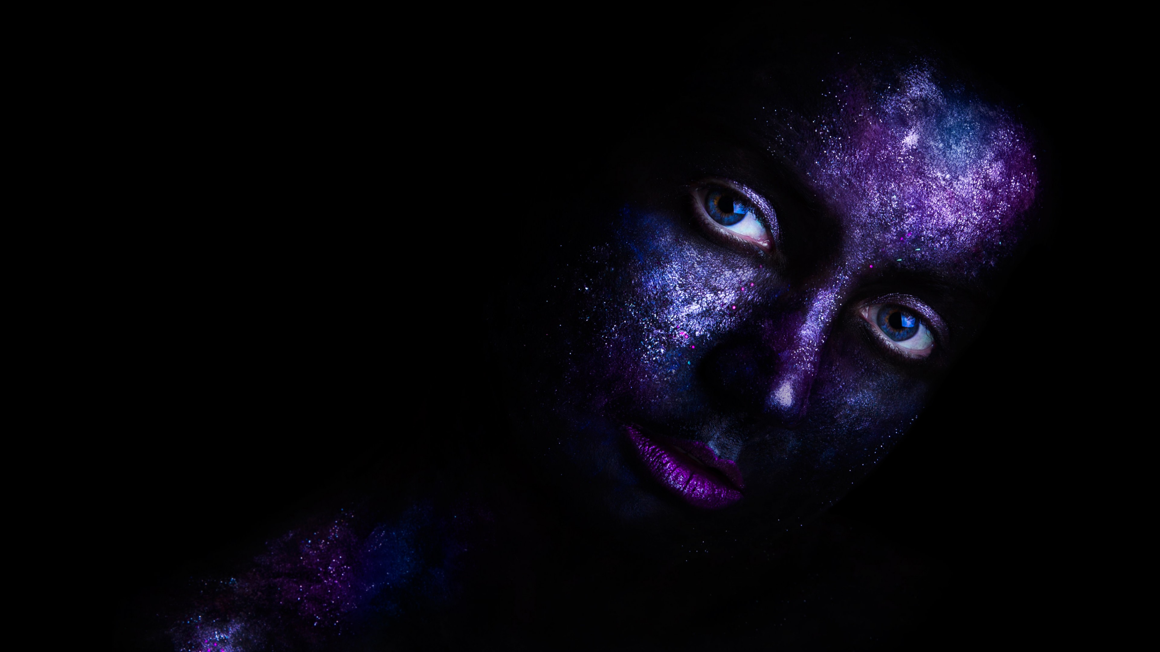 женщина с голубыми глазами и черным телом с фиолетовой краской