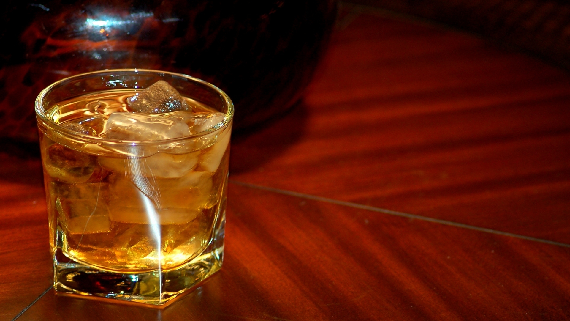 на столе со льдом сидит стакан алкоголя