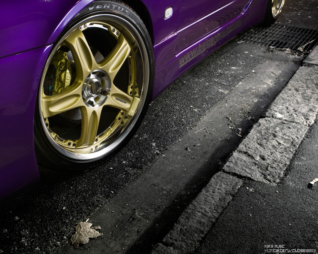 фиолетовый автомобиль, припаркованный на обочине дороги с желтым ободом