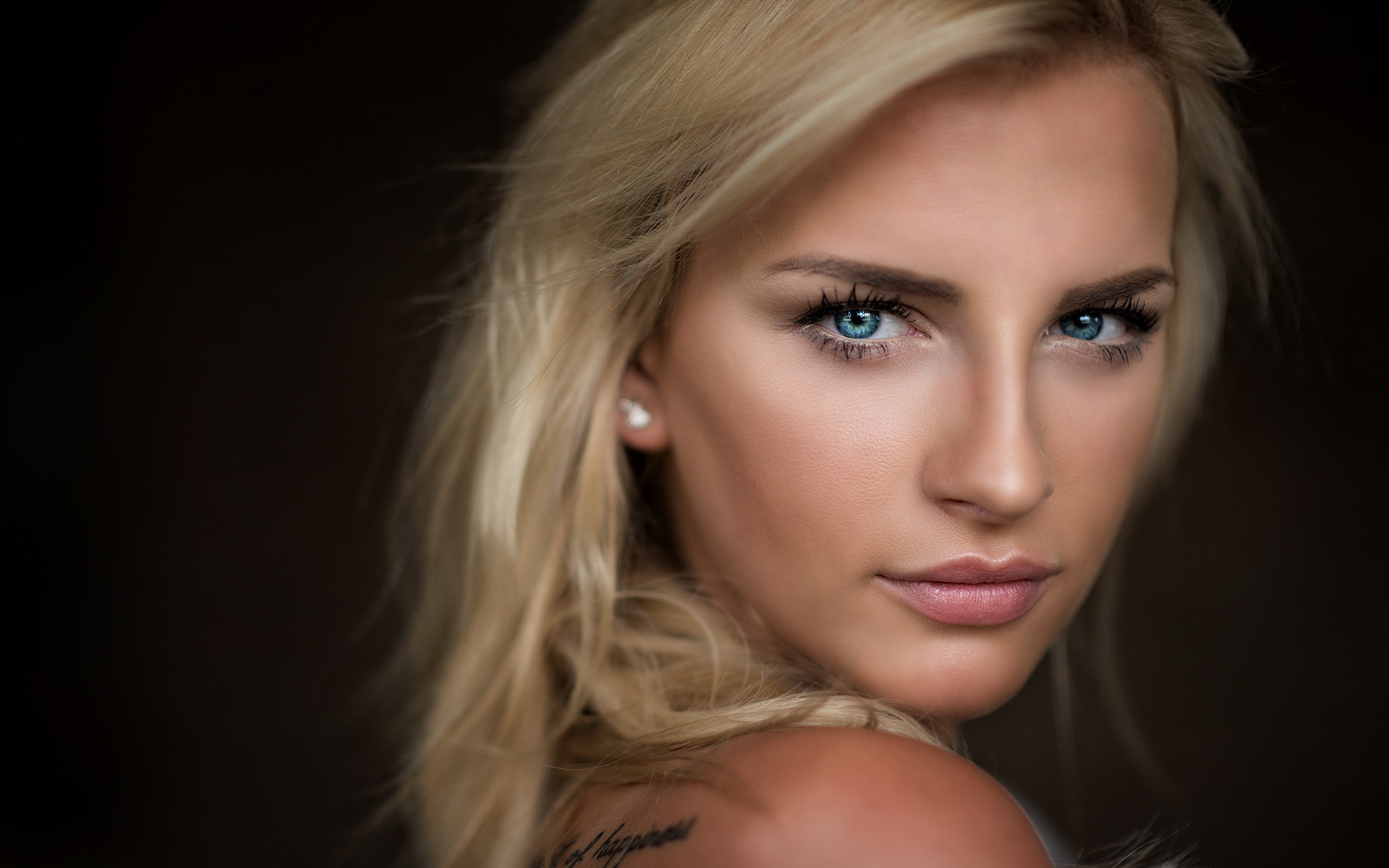блондинка с голубыми глазами и татуировкой на руке