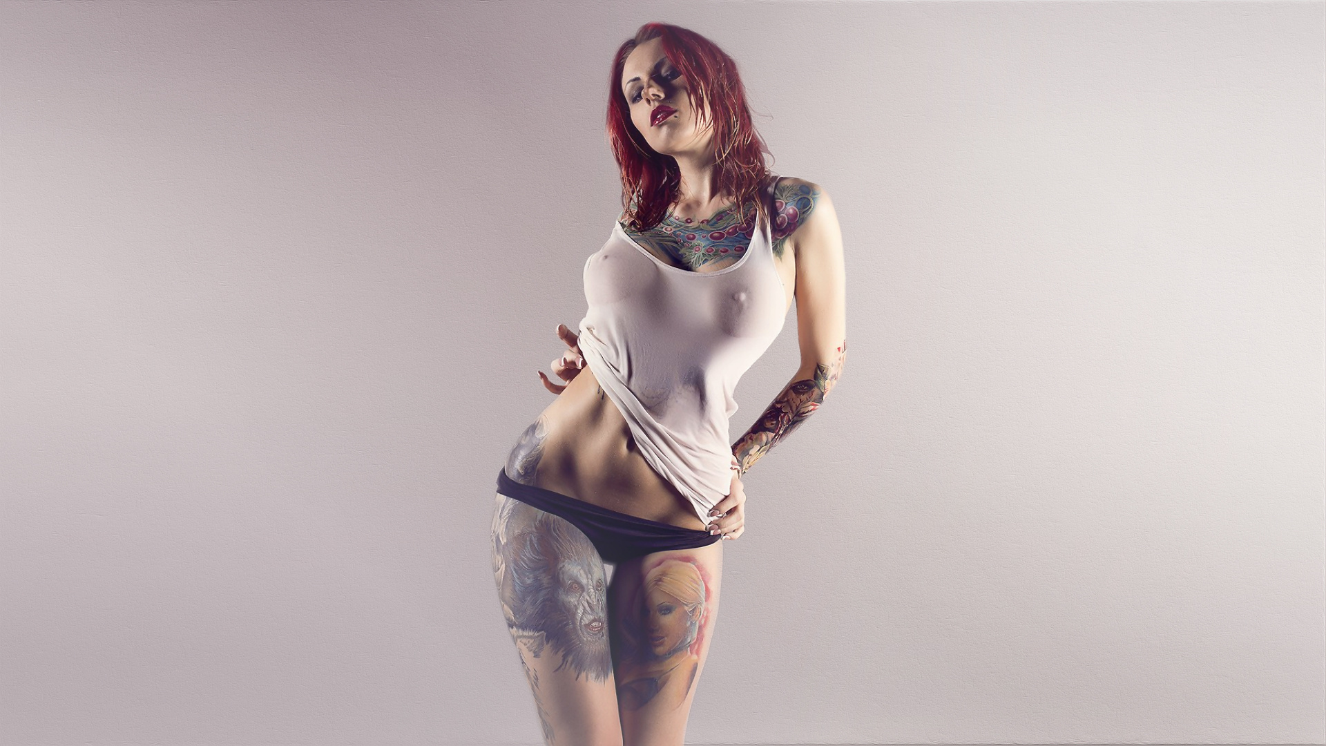 женщина с татуировками и белой крышкой танка позирует для фото