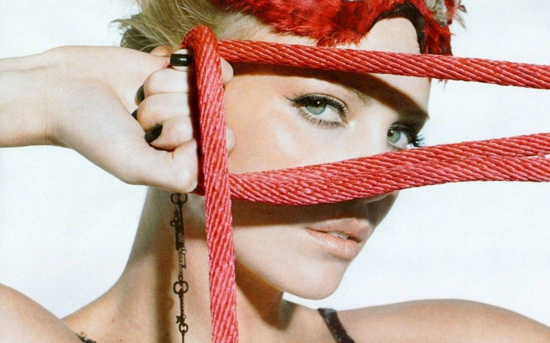 женщина с рыжими волосами и пирсингами, держащая красную веревку