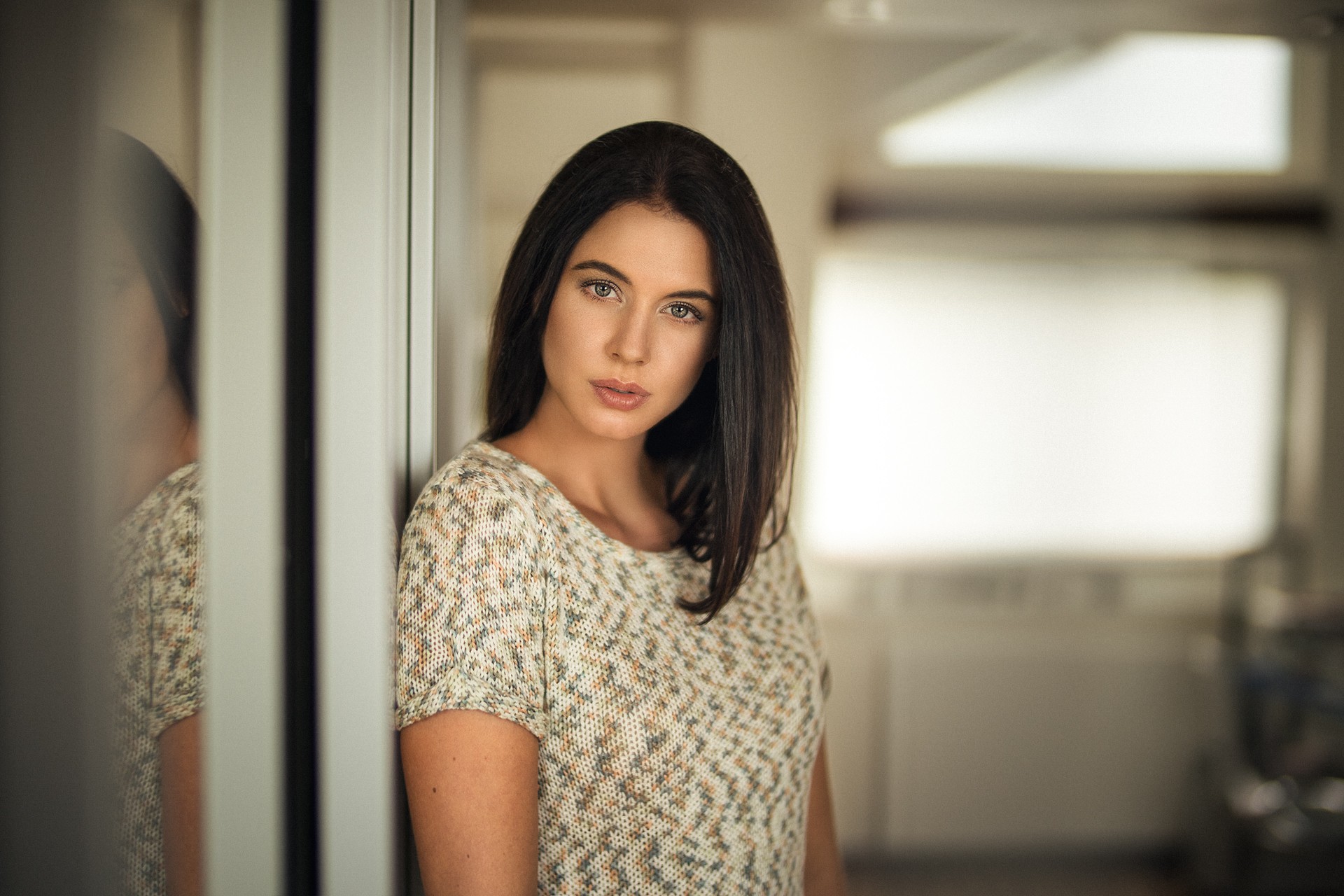 женщина стоит перед зеркалом и смотрит на себя