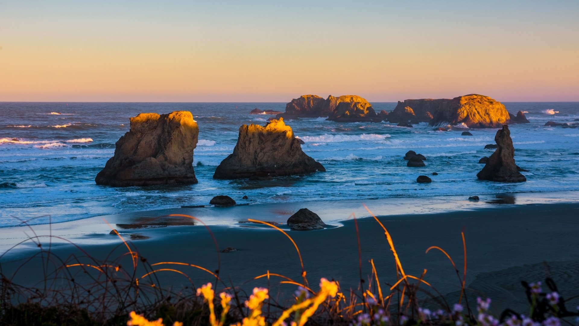есть несколько скал в воде рядом с пляжем