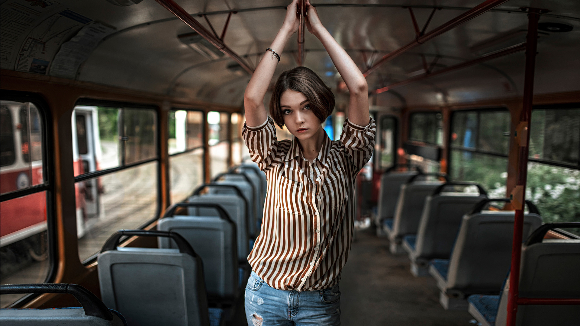женщина, стоящая в автобусе с поднятыми руками