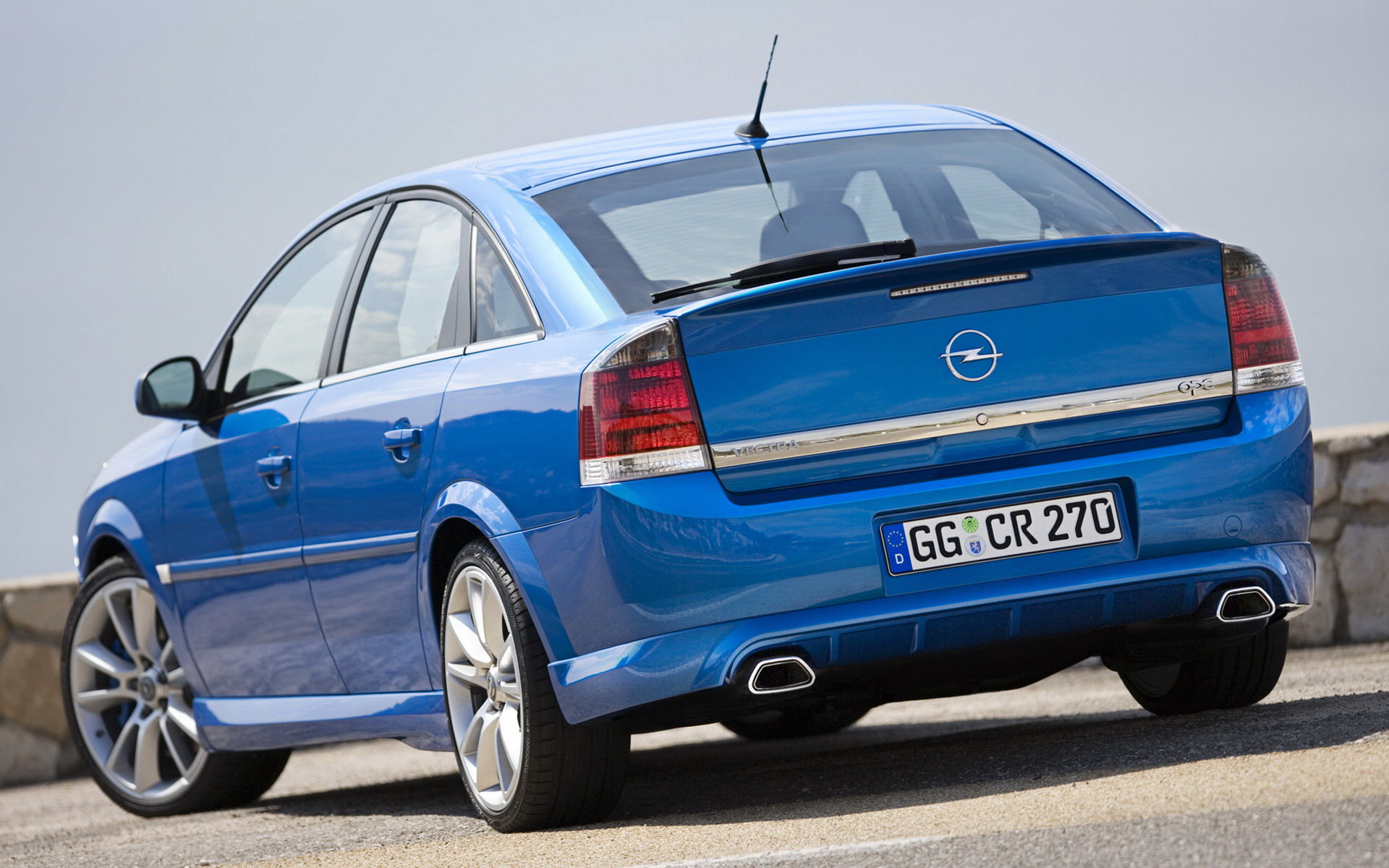 женщина синяя машина припаркована на улице со стеной на заднем плане