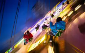 араффе катается на карнавале ночью, когда люди смотрят