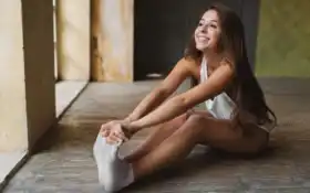 женщина, сидящая на полу со скрещенными ногами